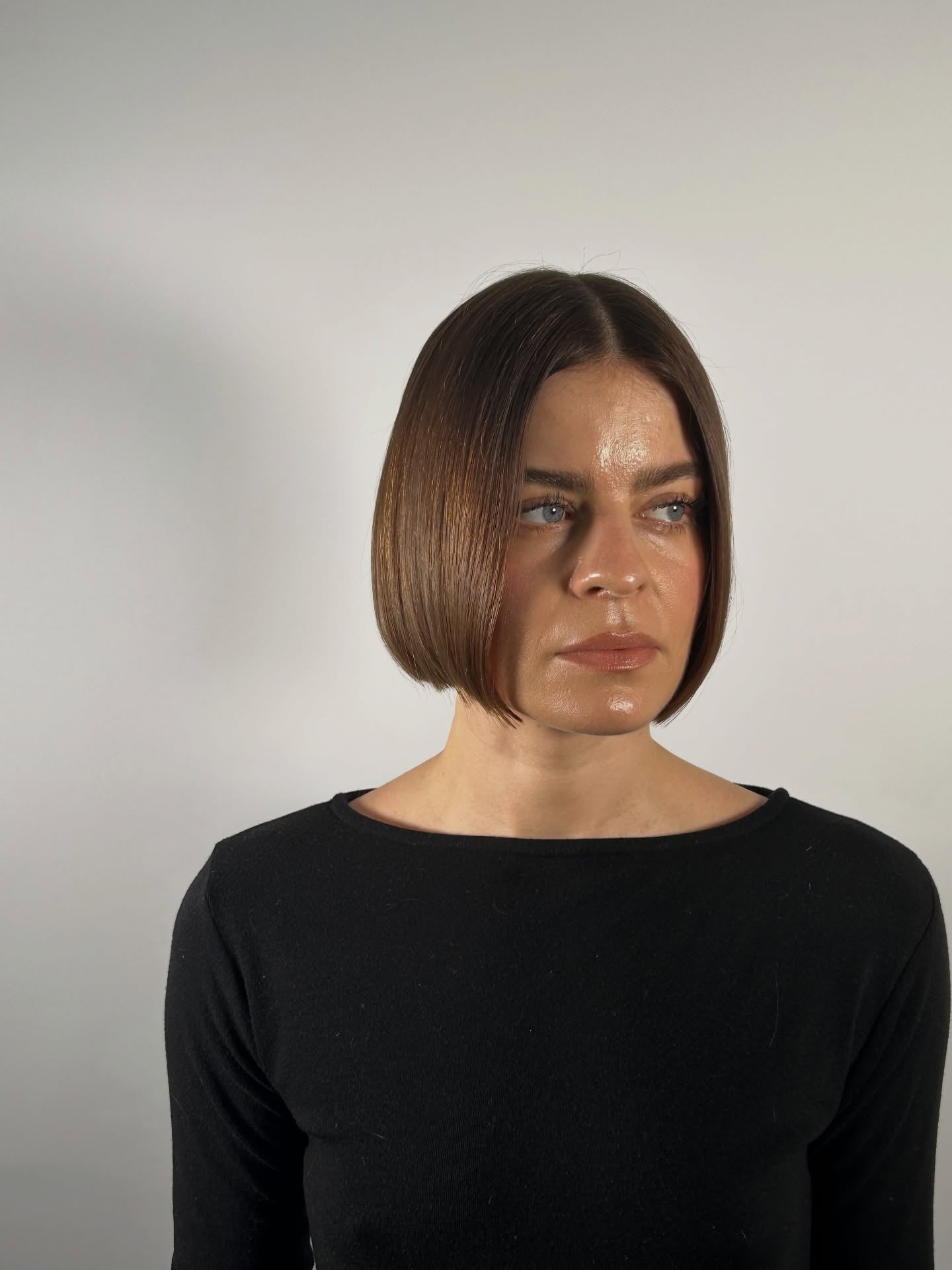 Sleek blunt brunette chin-length bob with center part