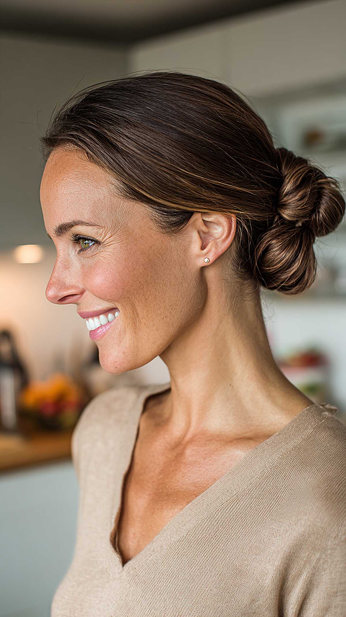 Sleek low bun with center part on brunette hair