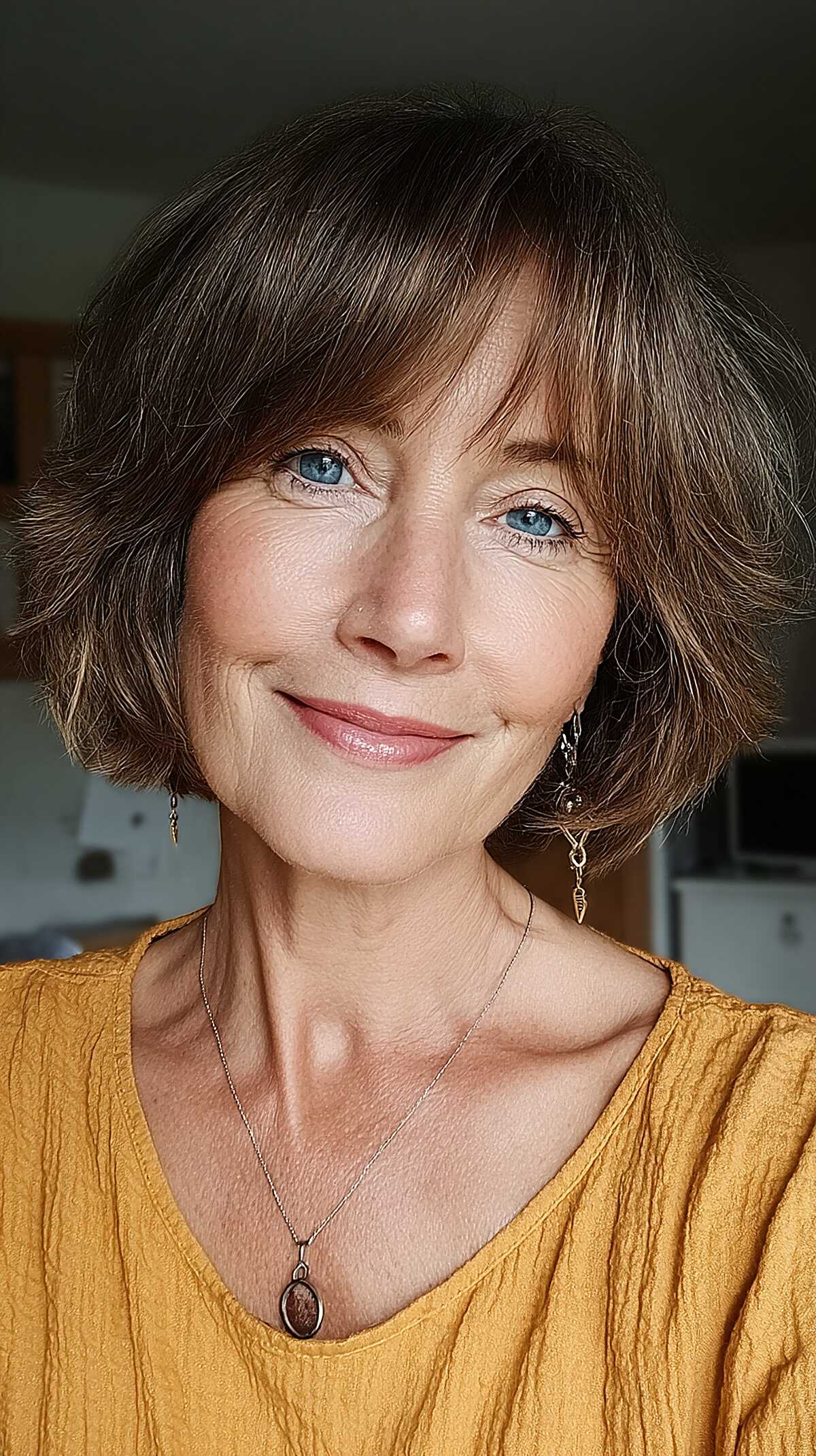 Short rounded dark brown bob with wispy curtain bangs