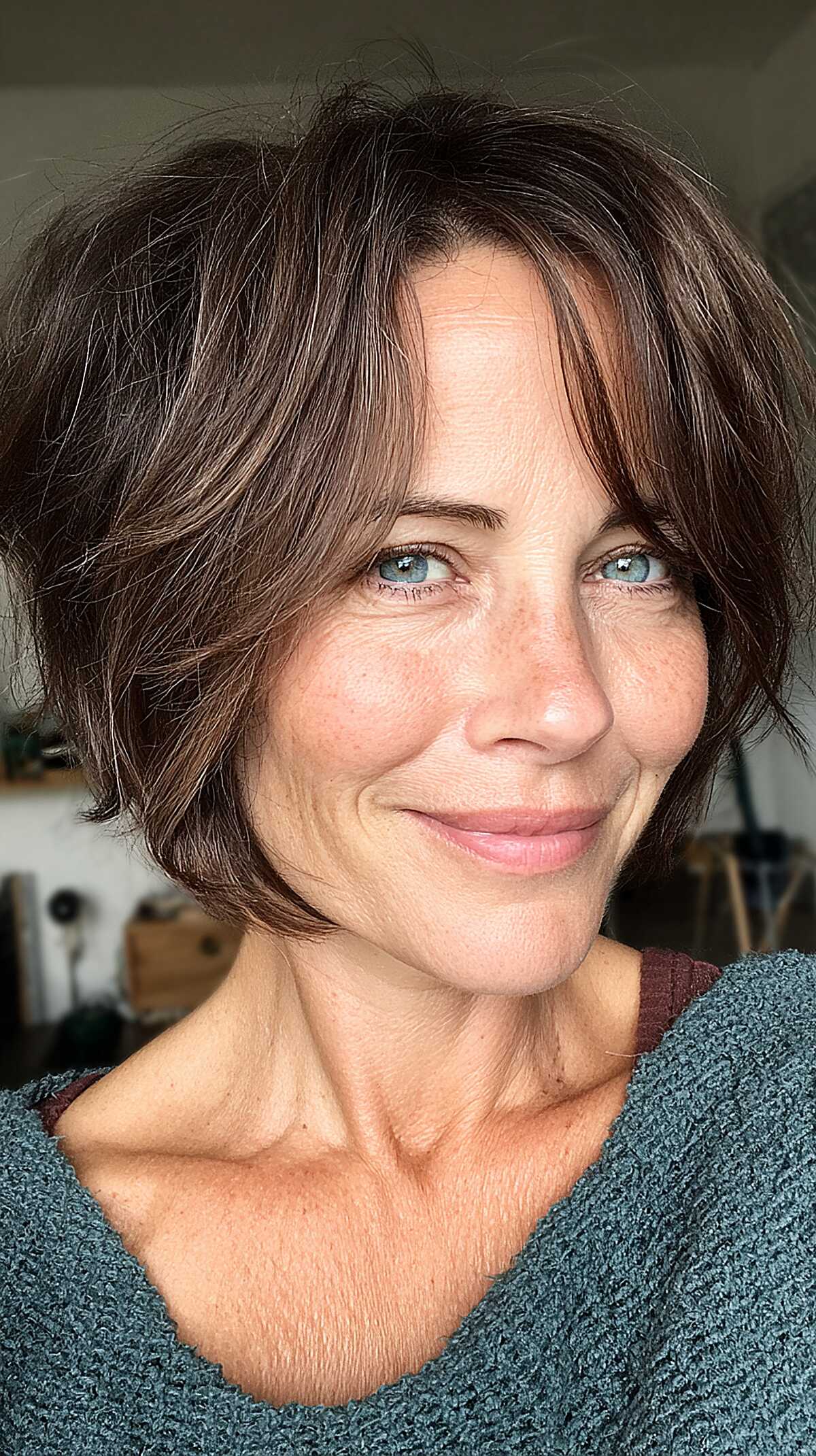 Choppy chin-length dark brown bob with soft curtain bangs
