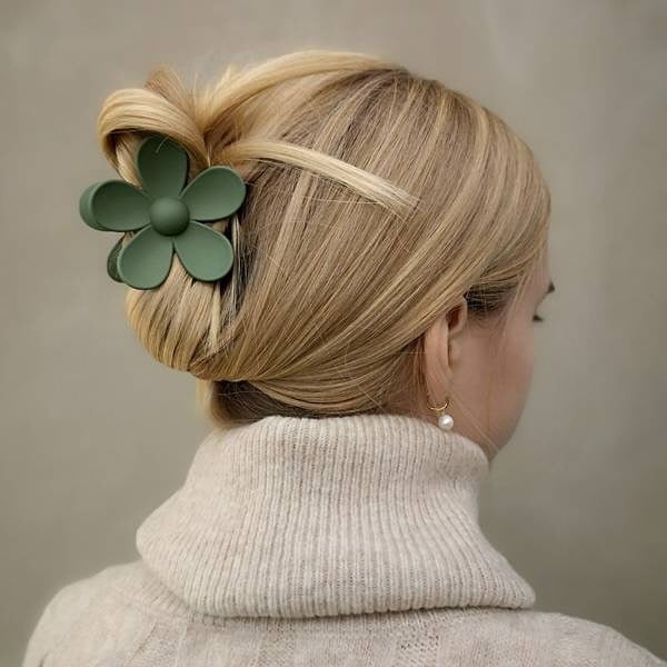 Blonde hair twisted up with a green flower claw clip