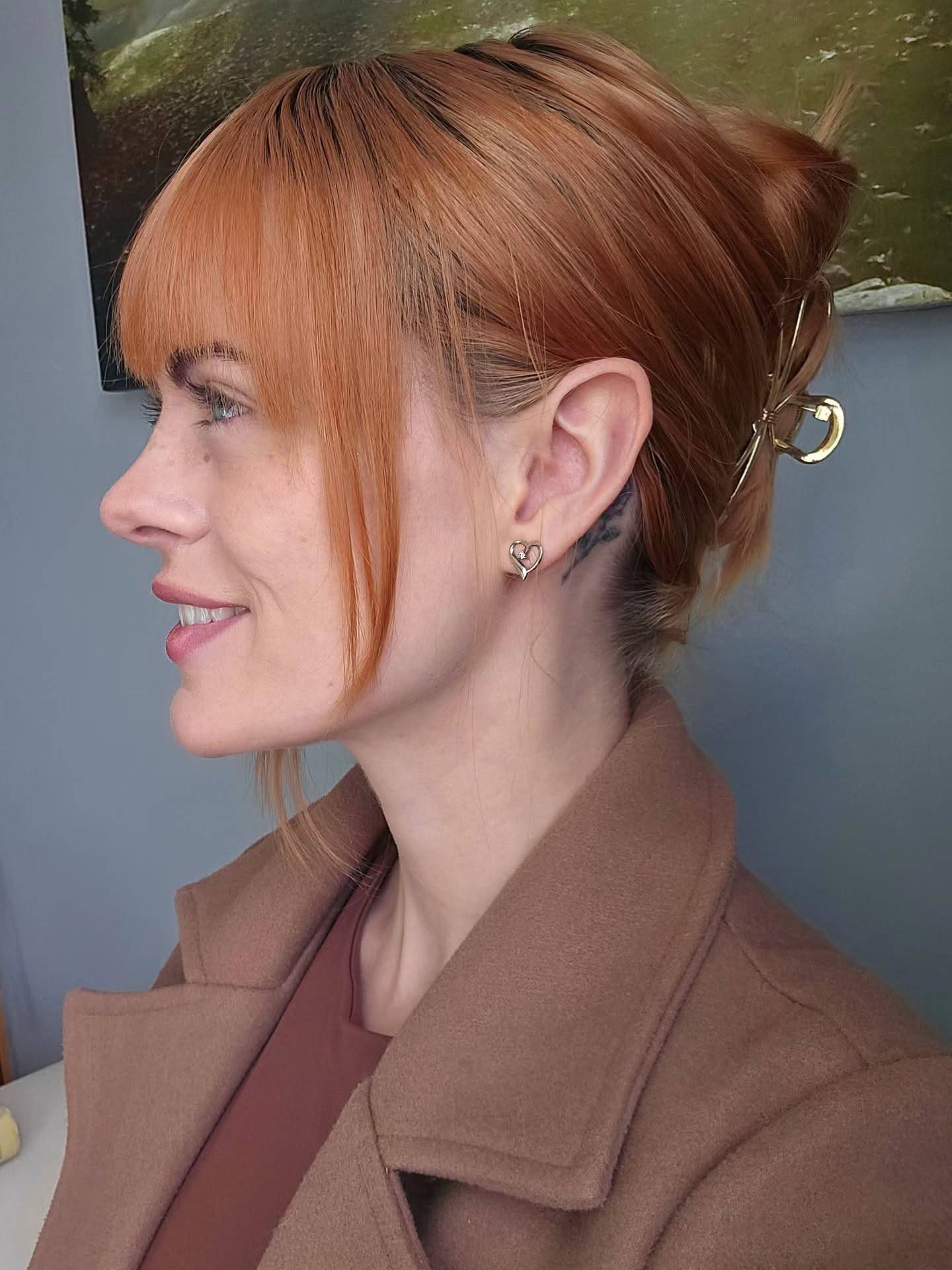 Copper red hair with bangs clipped up in a gold claw