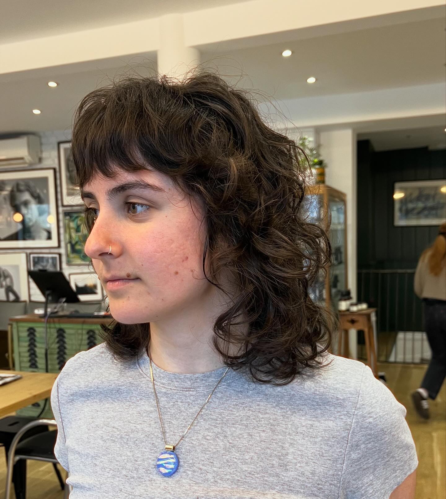 Curly dark brunette shoulder-length shag with bangs
