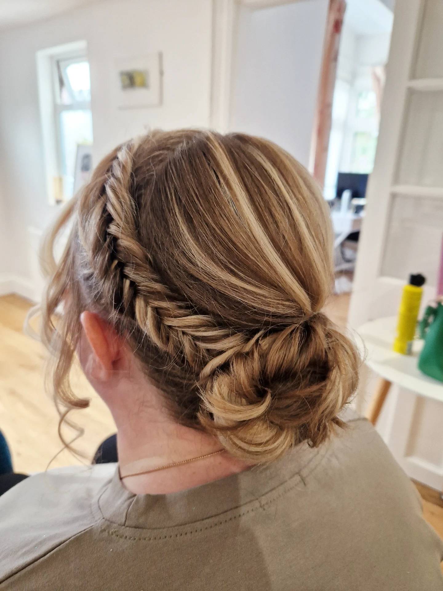 Blonde highlighted fishtail braid tucked into a low bun