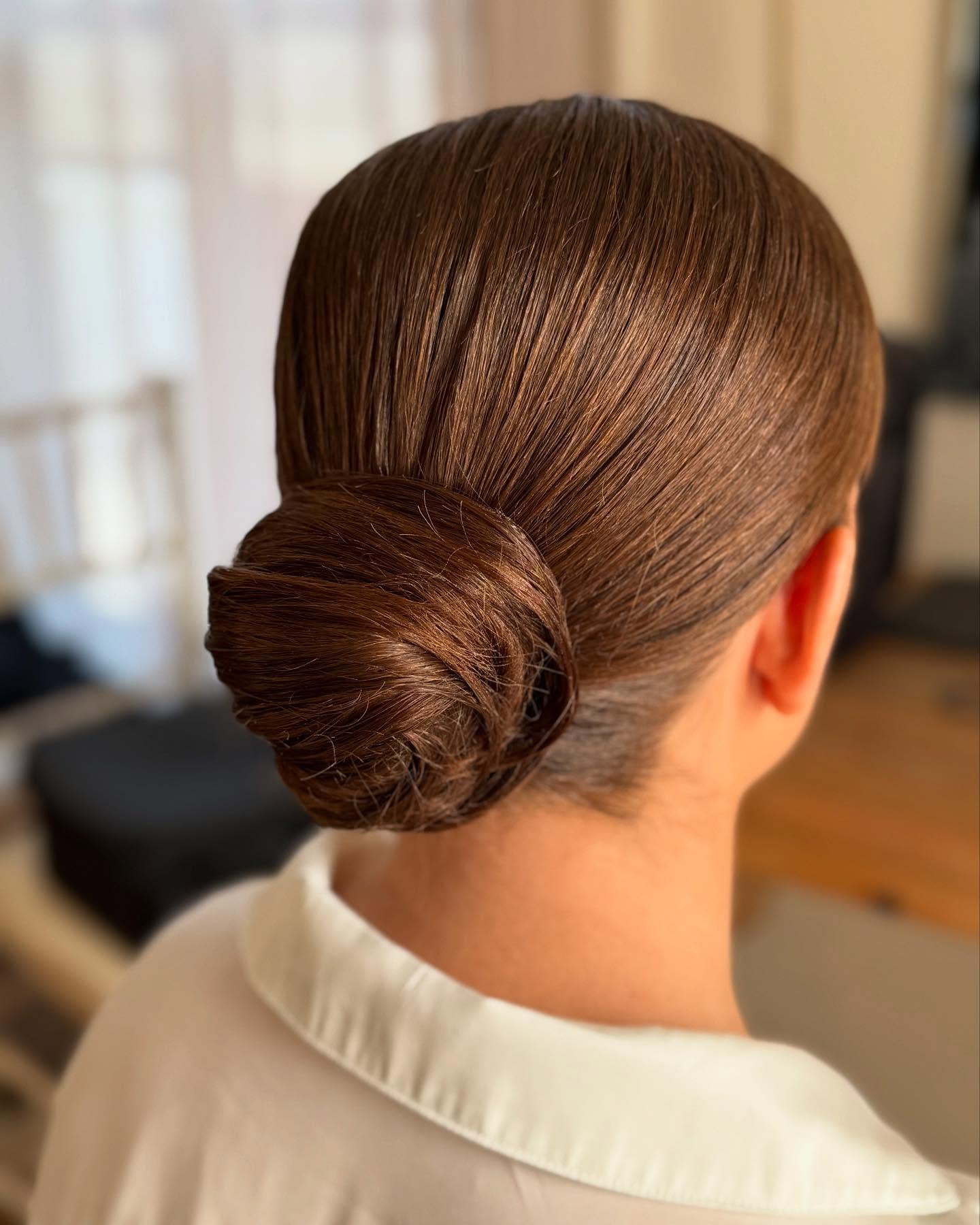 Sleek polished low bun on smooth brunette hair