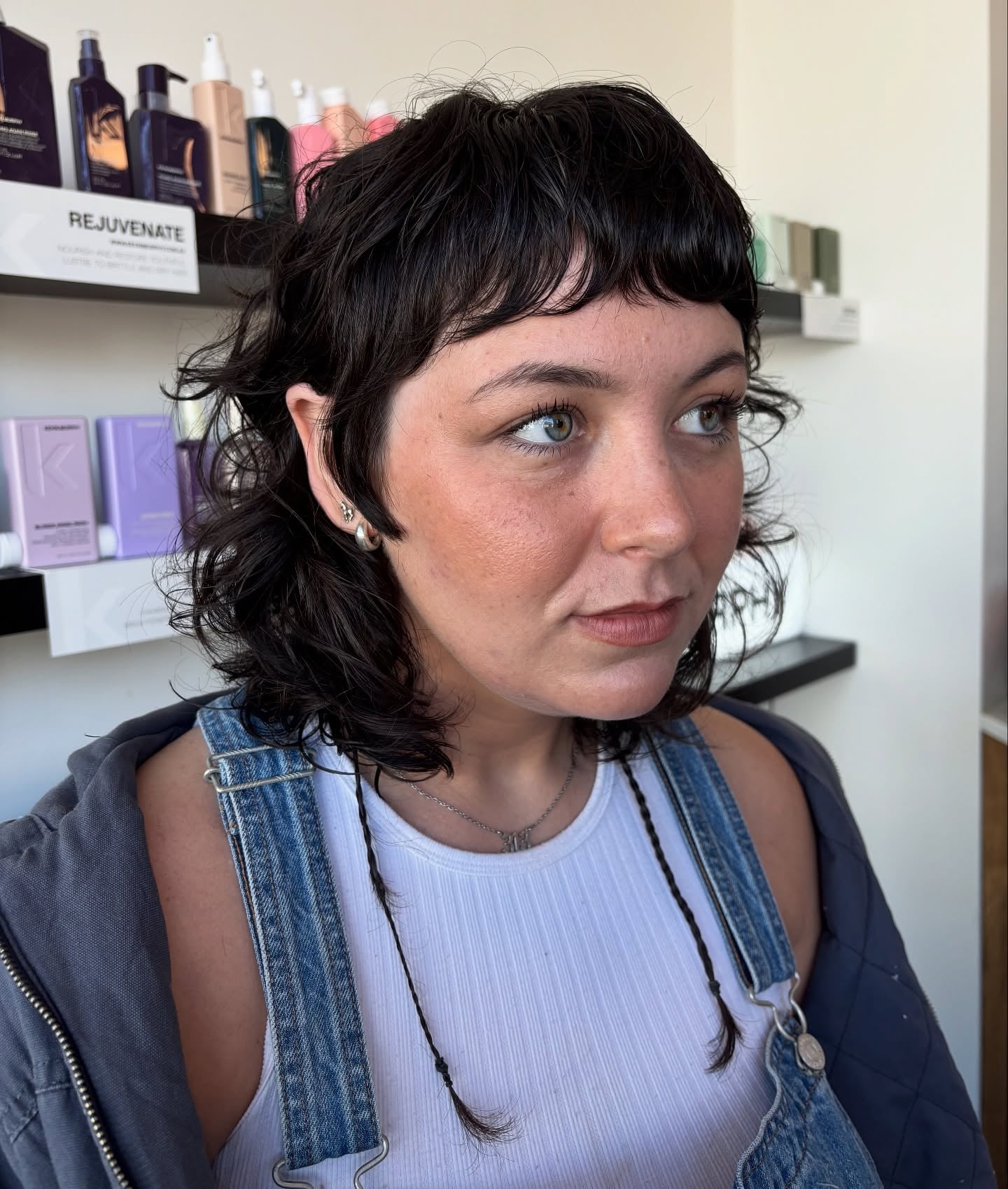 Black wavy micro-shag with baby bangs at jaw length