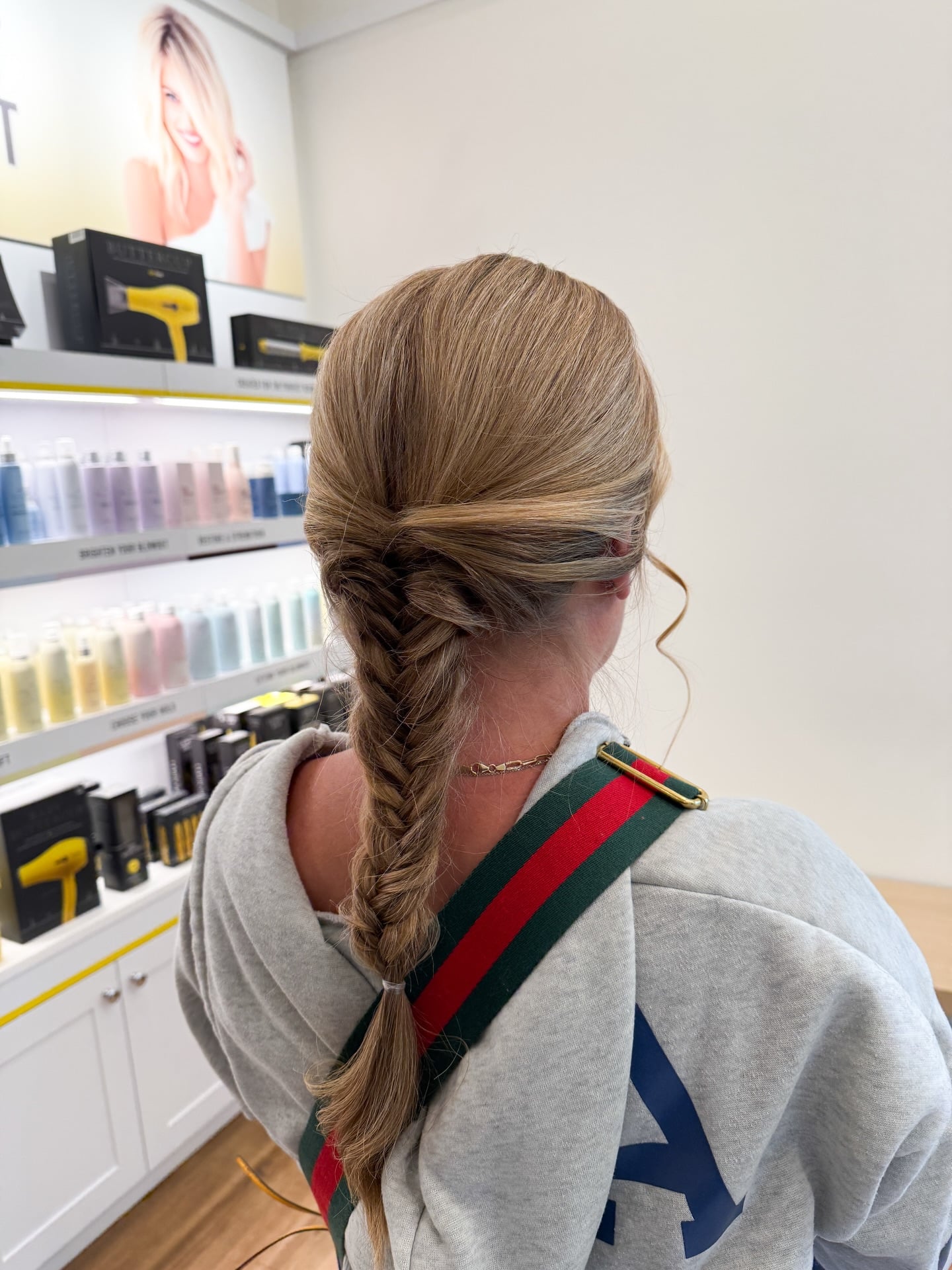 Low fishtail braid on straight dark blonde hair