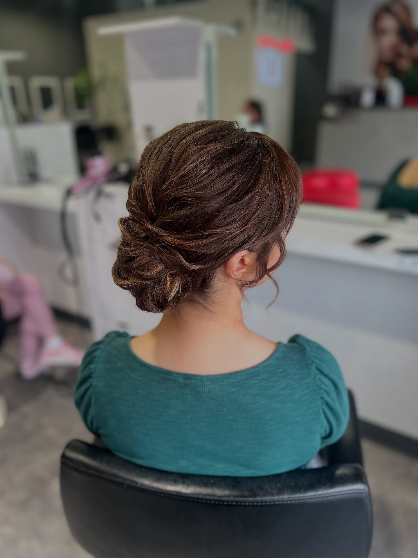 Textured brown low chignon with loose waves at the nape