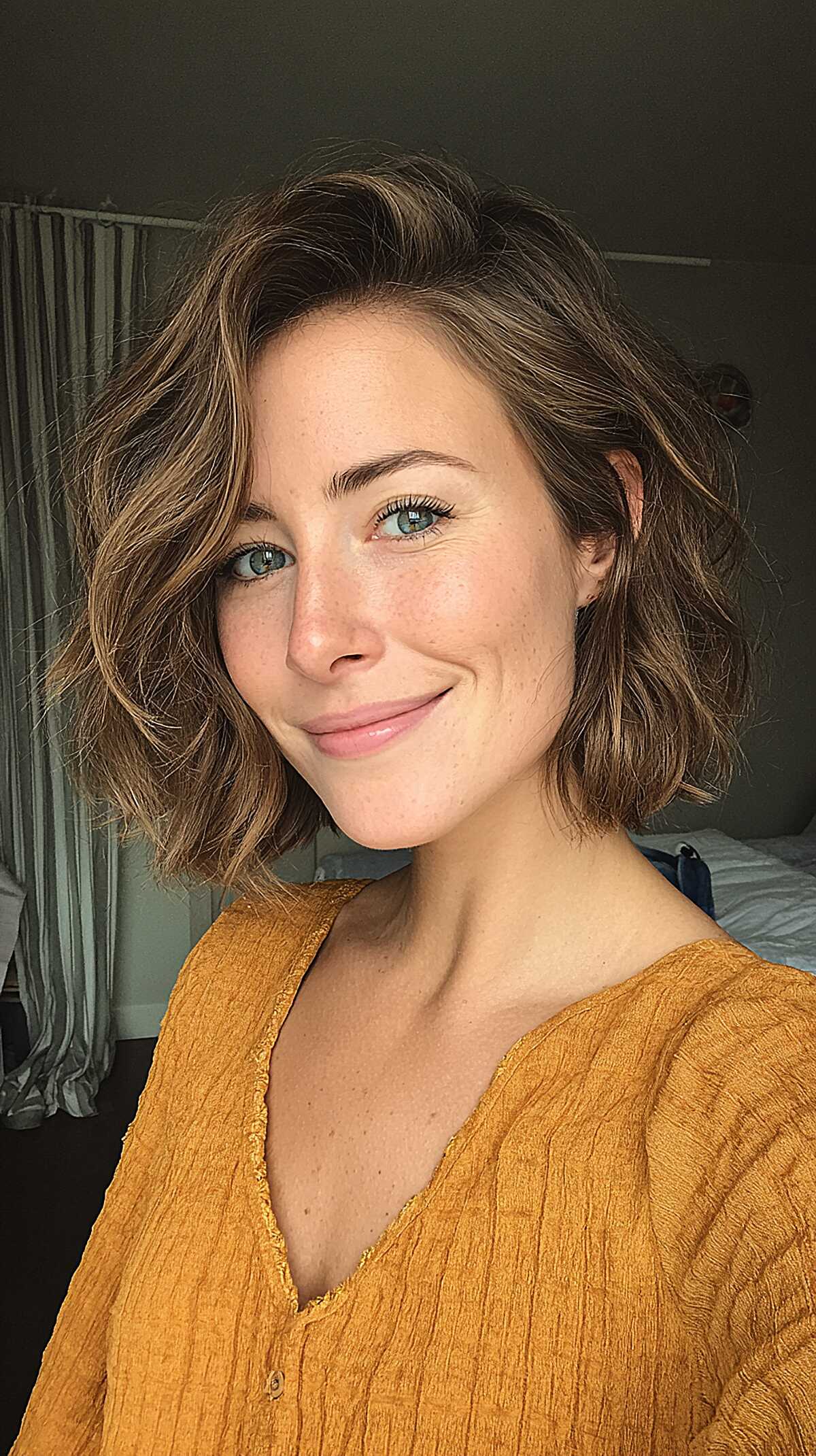 Tousled chin-length chestnut brown wavy bob with side part