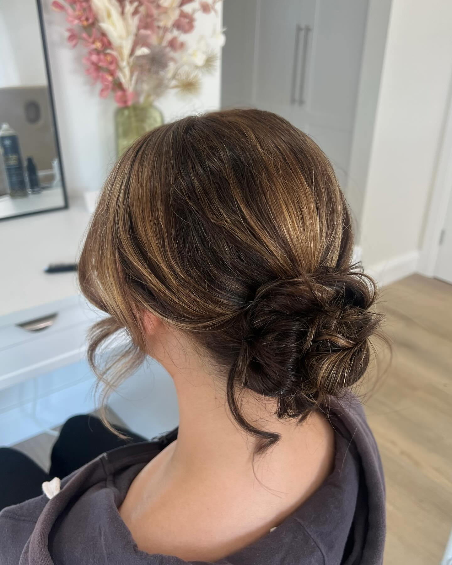 Loose messy low bun with brunette balayage highlights