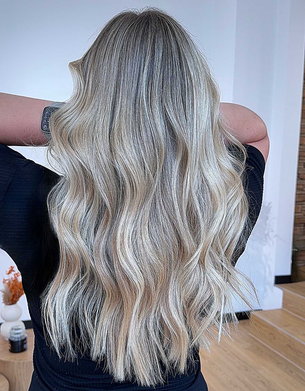 Long ash blonde waves with smoky gray undertone and roots
