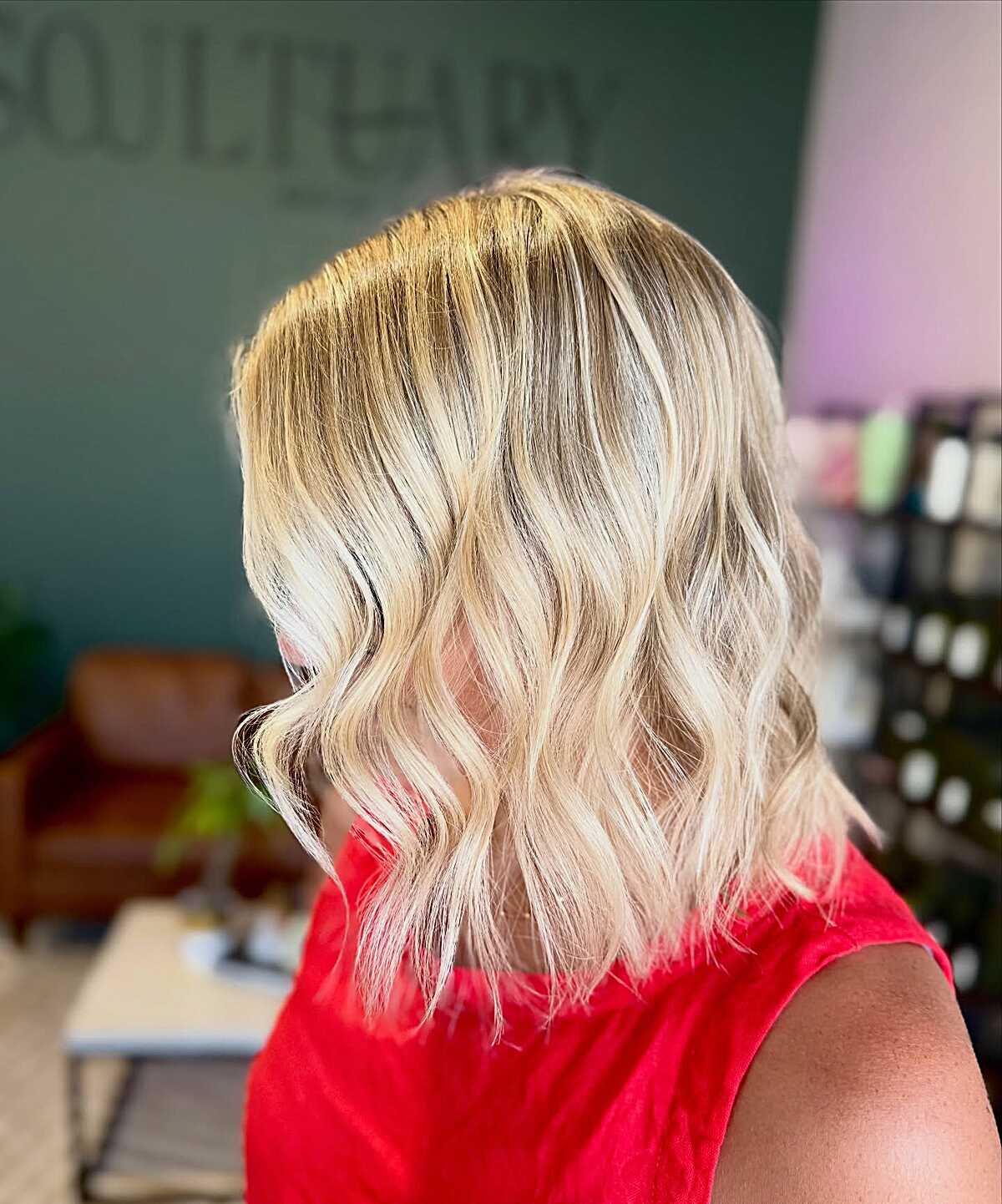 Short bright blonde wavy bob with warm and cool dimension