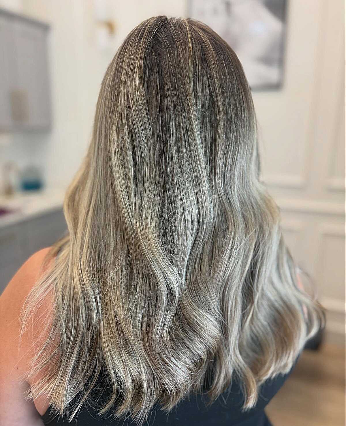 Medium length cool-toned mushroom blonde with soft waves