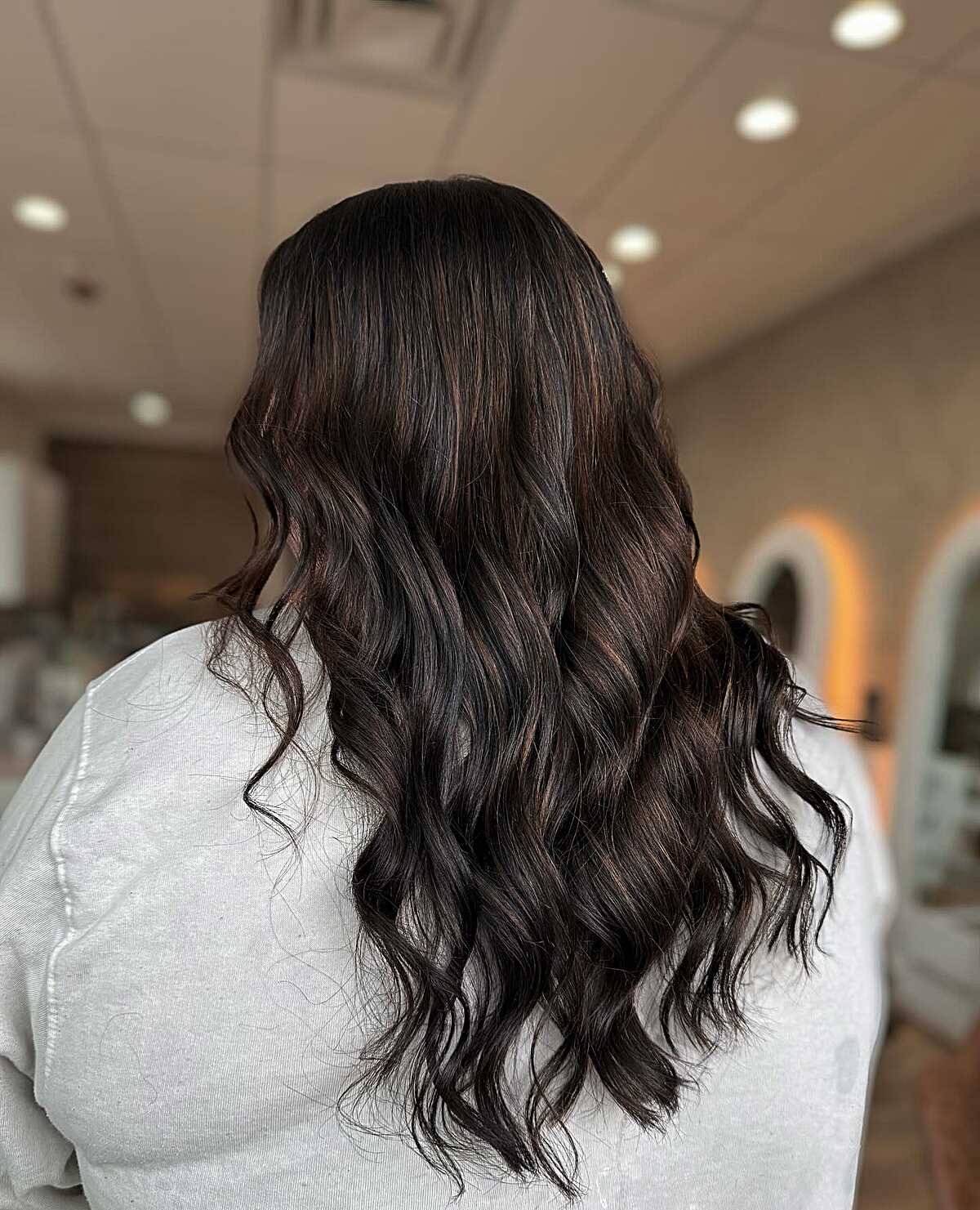 Long dark brunette waves with subtle burgundy undertone