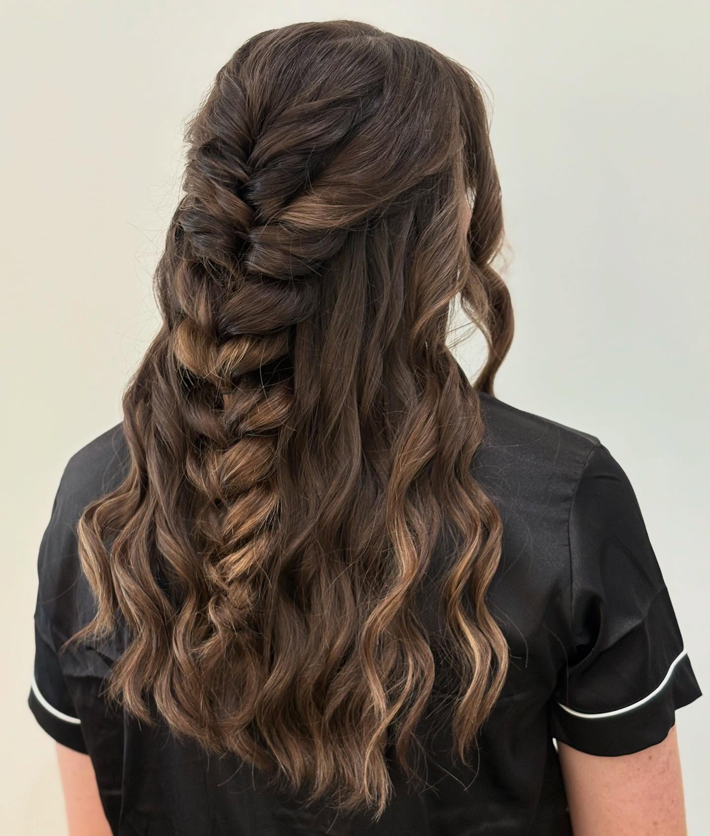 Half-up fishtail braid with loose brunette waves