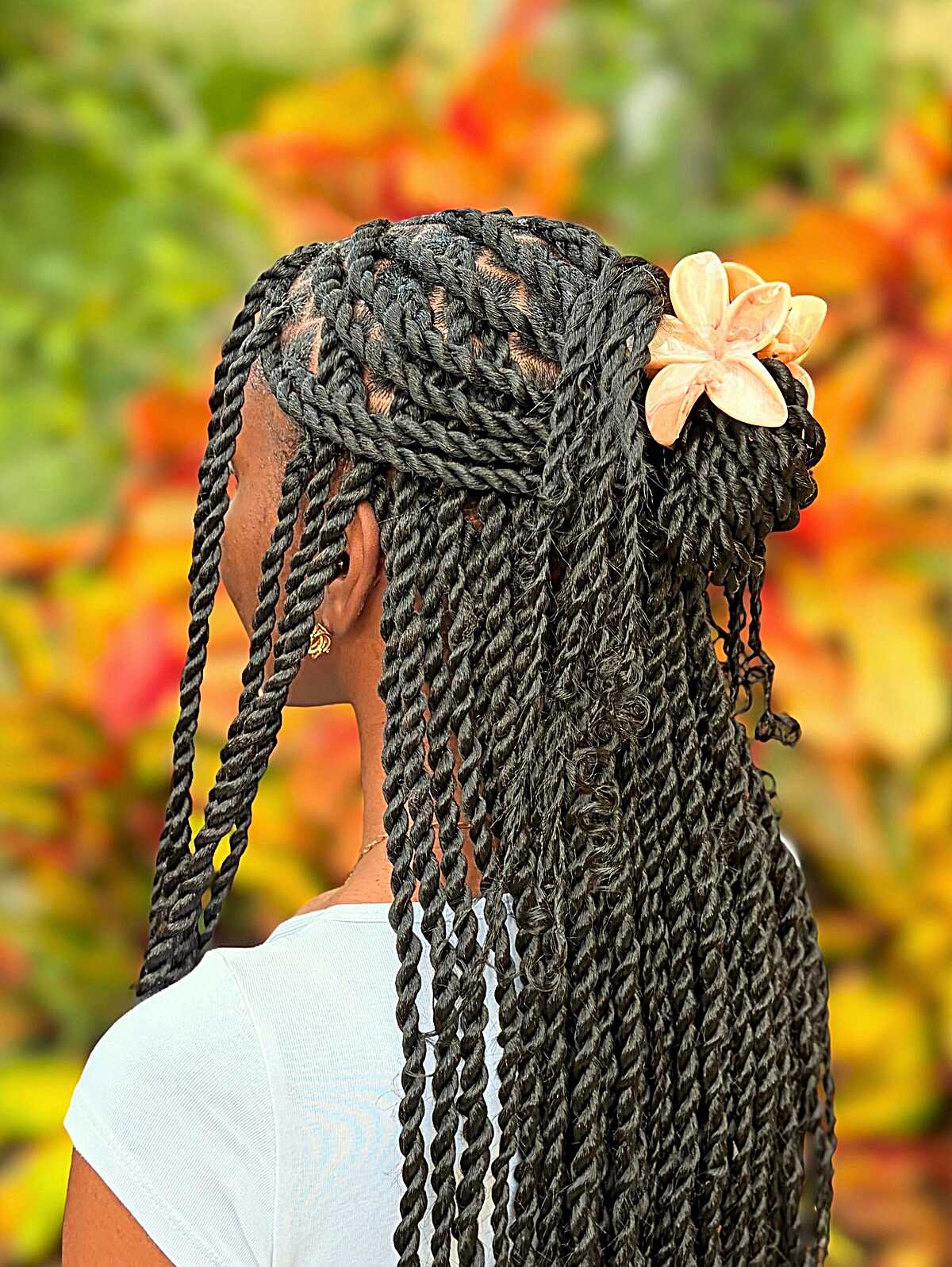 Black Senegalese twists in half updo with flower clip