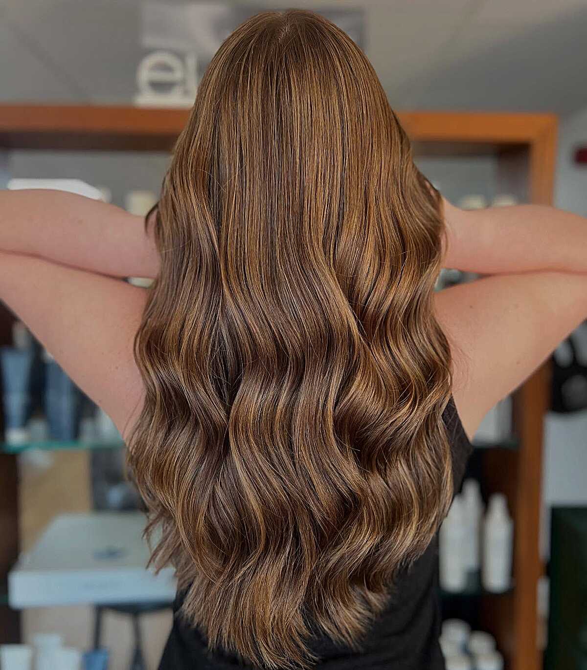 Long warm brunette waves with golden caramel highlights