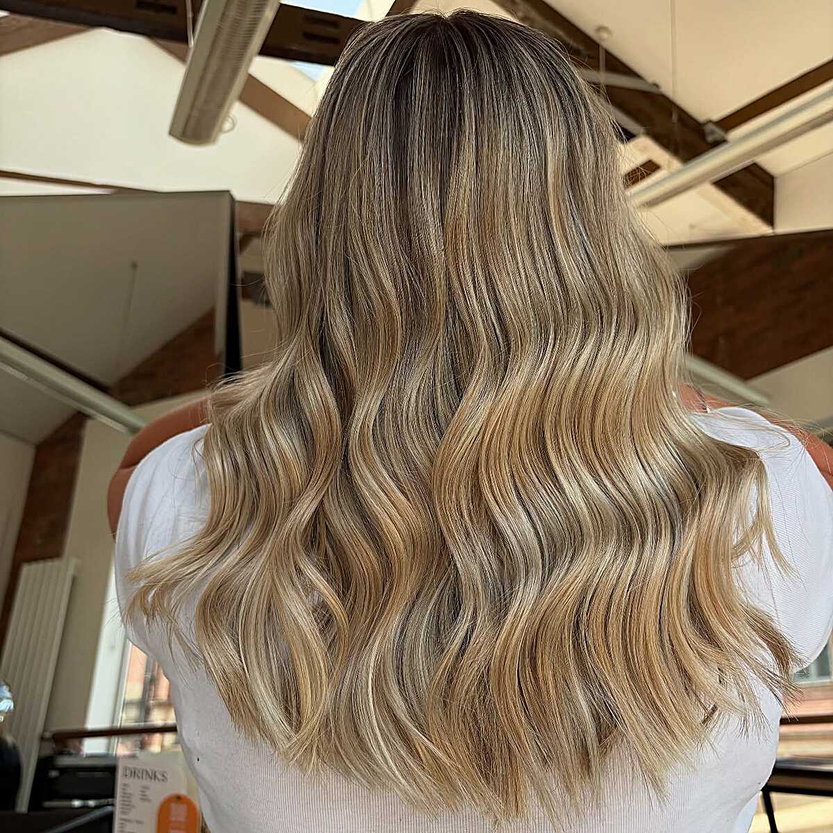 Medium length golden honey blonde balayage with dark roots