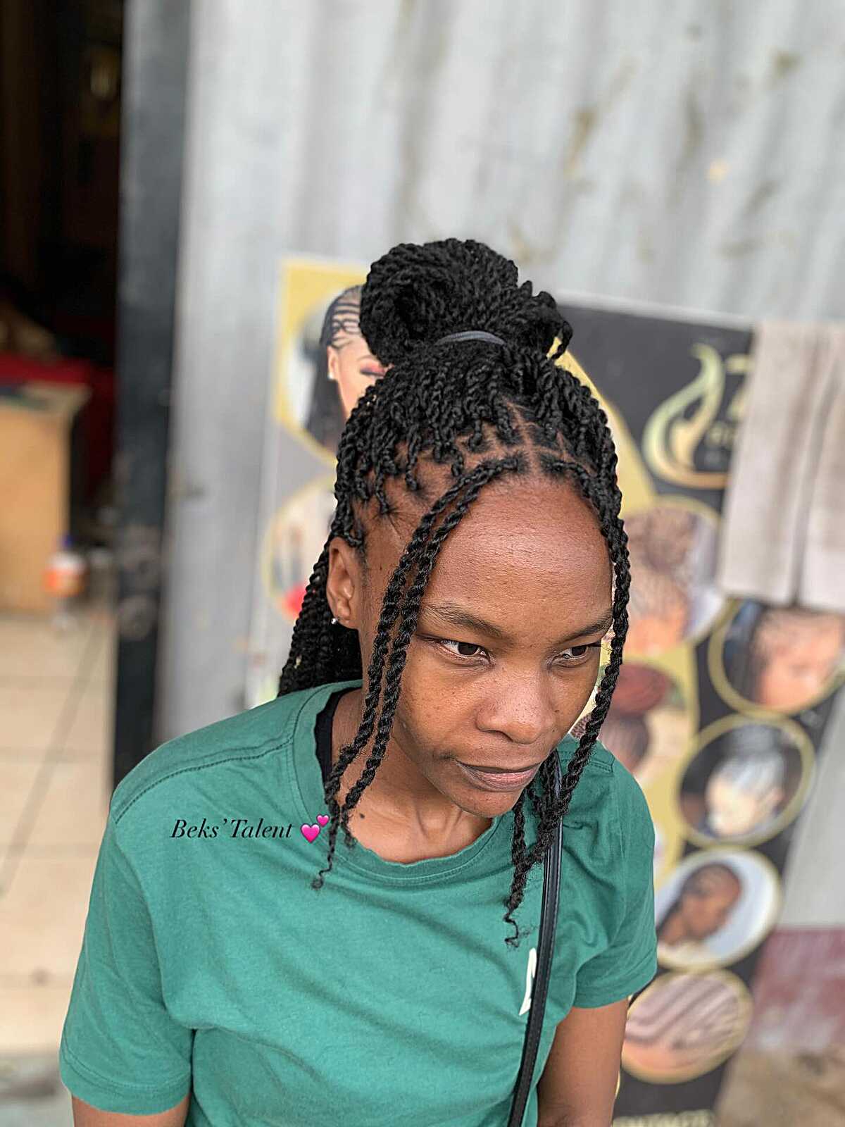 Black twists pulled into a high bun with loose pieces