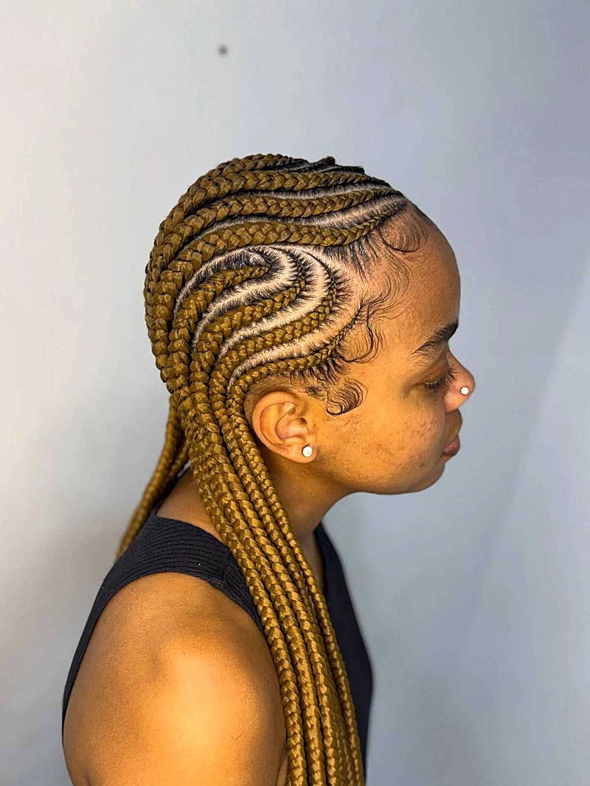 Honey blonde feed-in cornrows with curved pattern