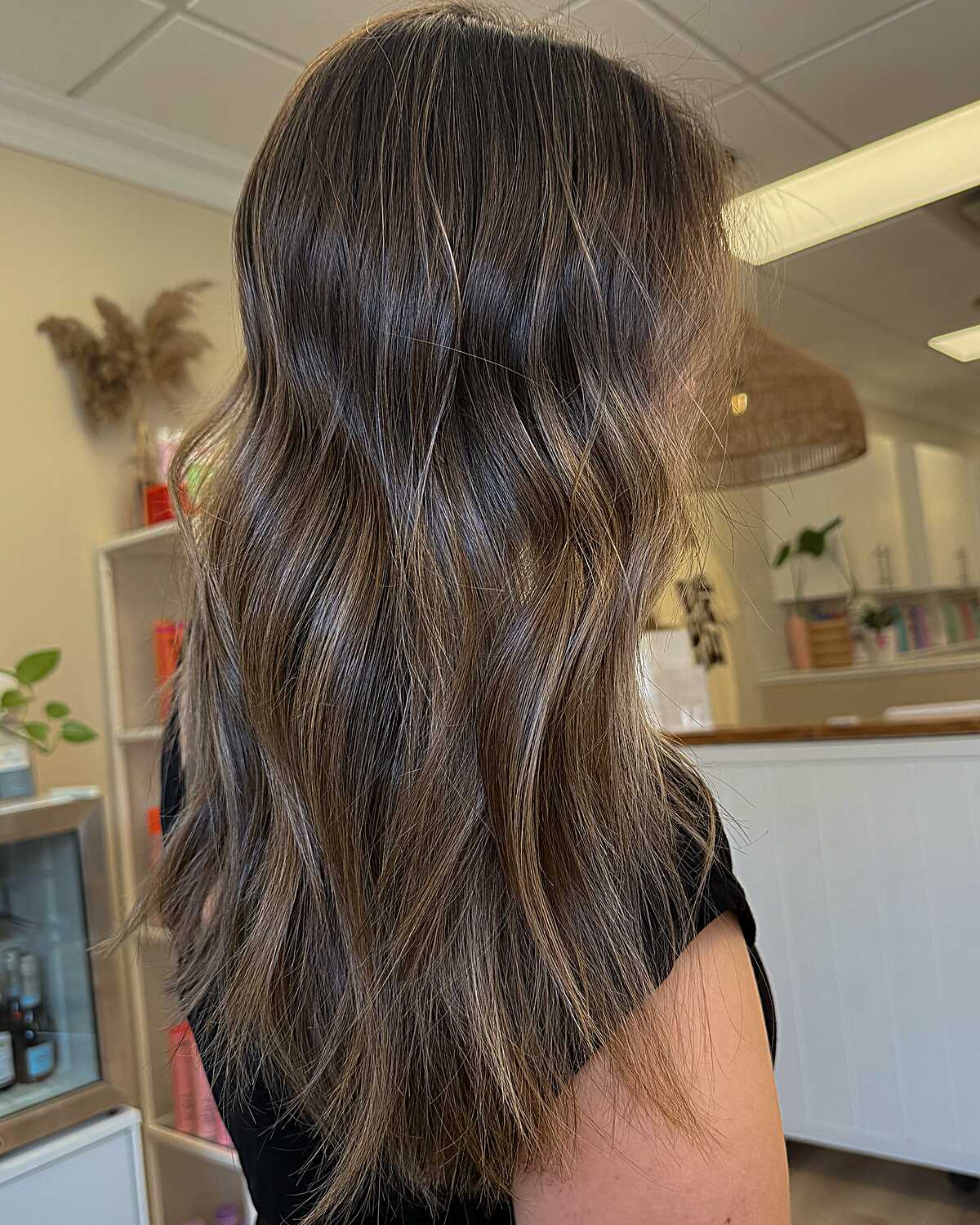 Long wavy brunette hair with sandy sun-kissed highlights