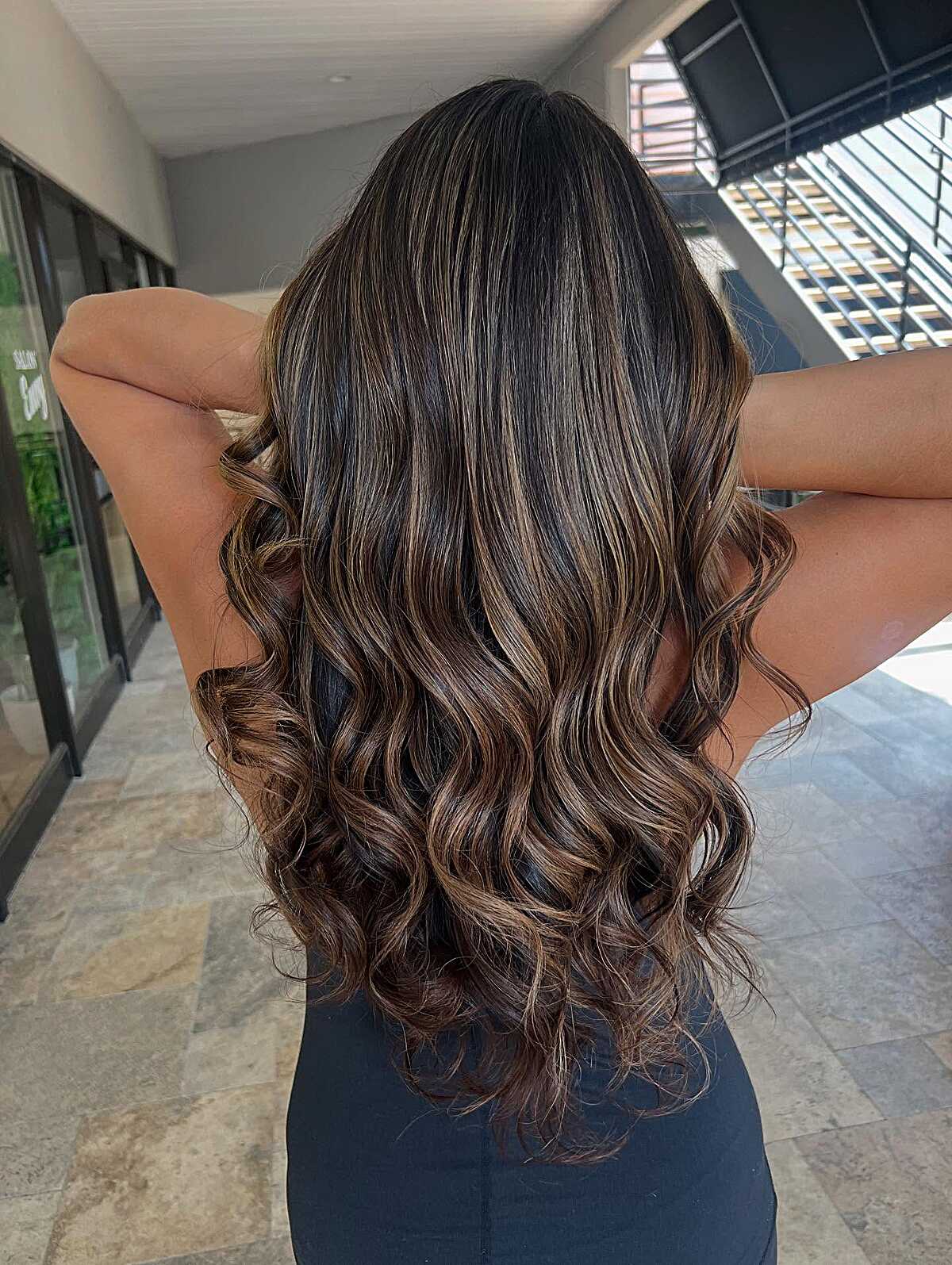 Long dark curled brunette with honey highlights at ends