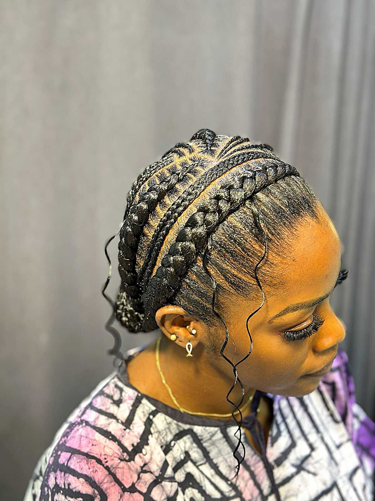 Cornrow updo with mixed braid sizes and tendrils