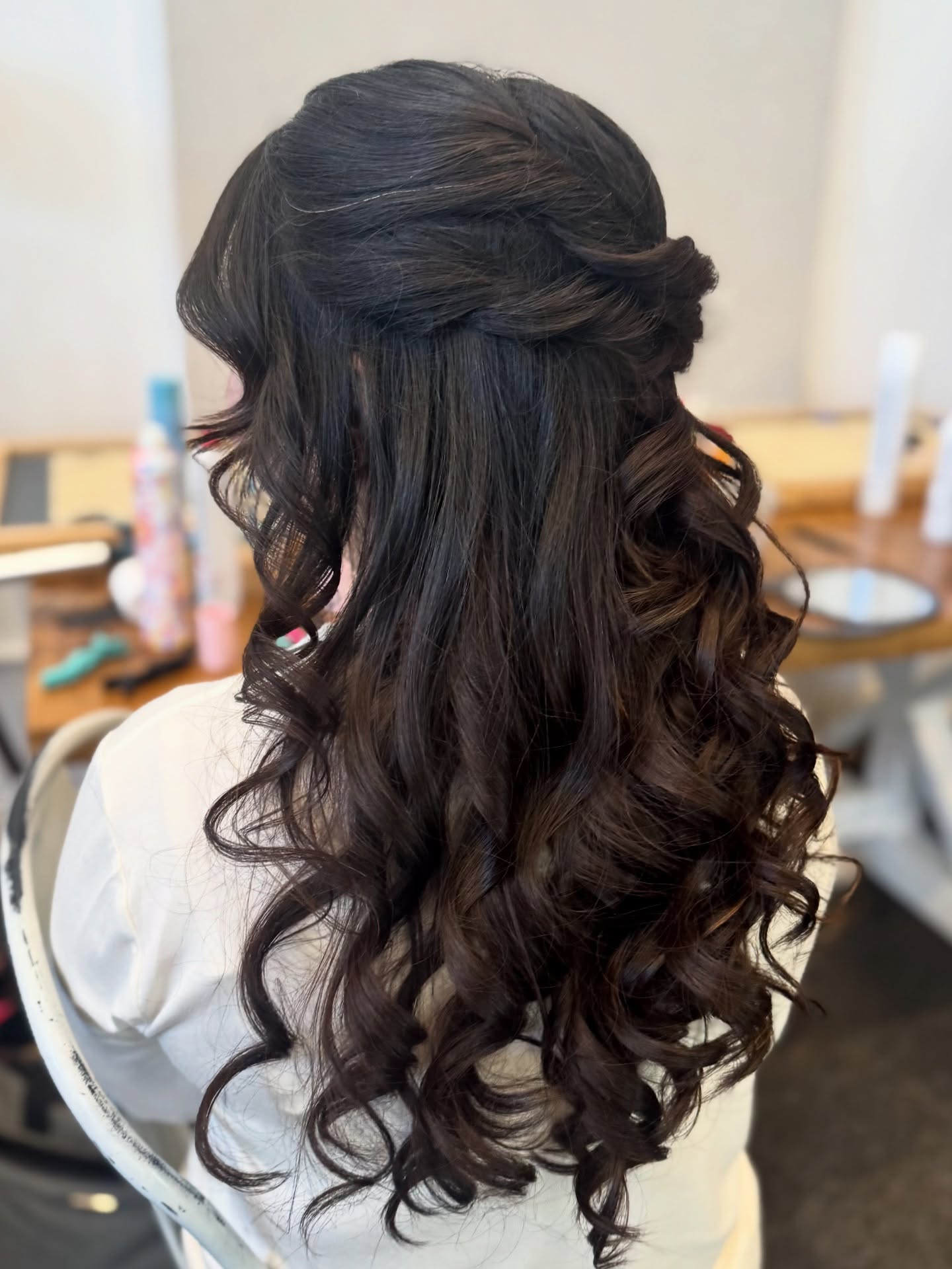 Half-up twisted style with long dark curls falling down