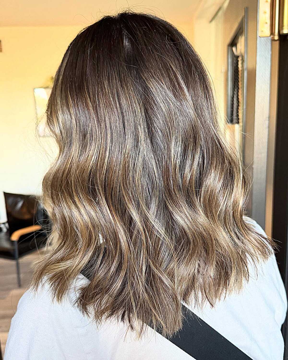 Medium-length bronde hair with dark roots and waves