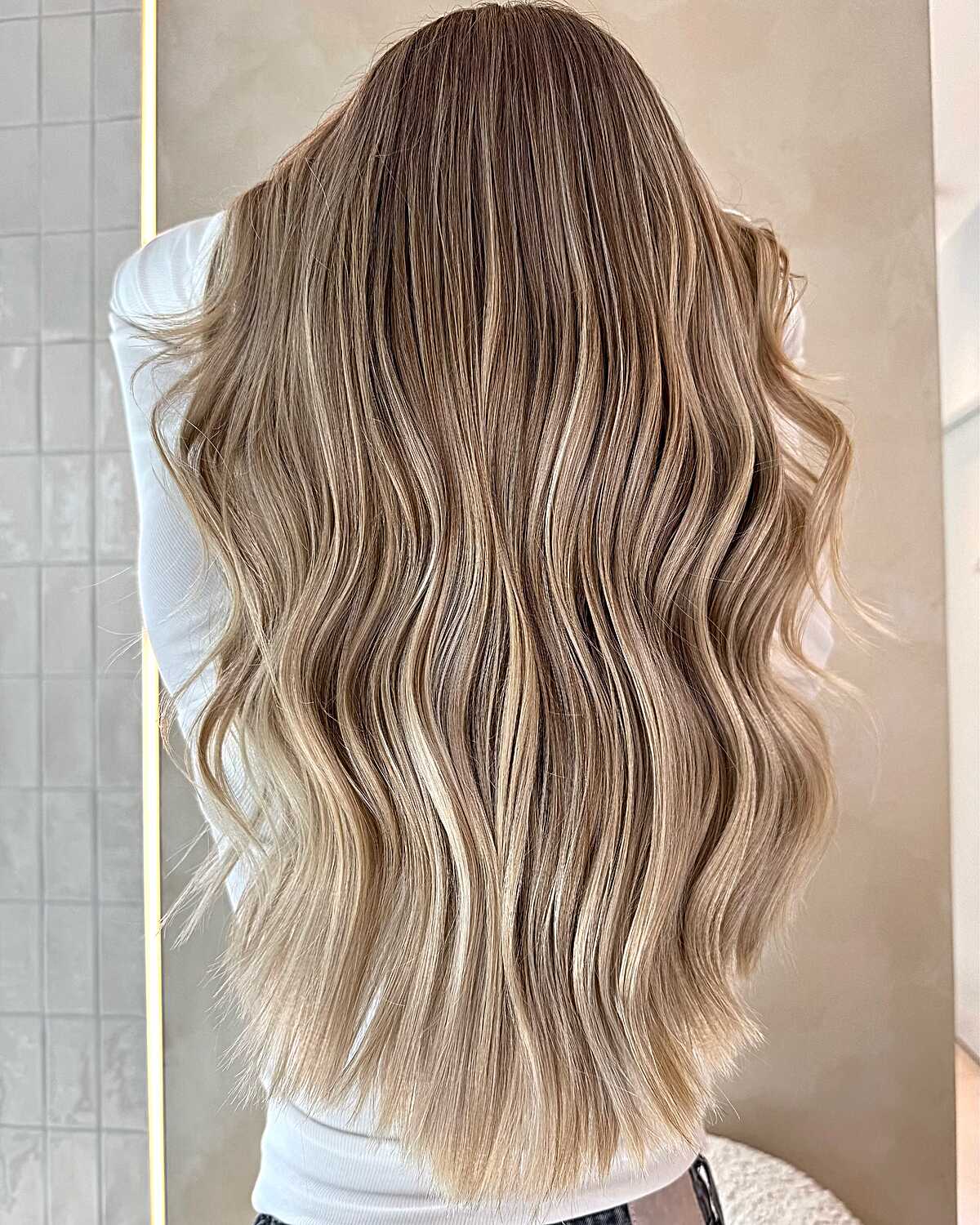 Long brunette to sandy blonde balayage with soft waves