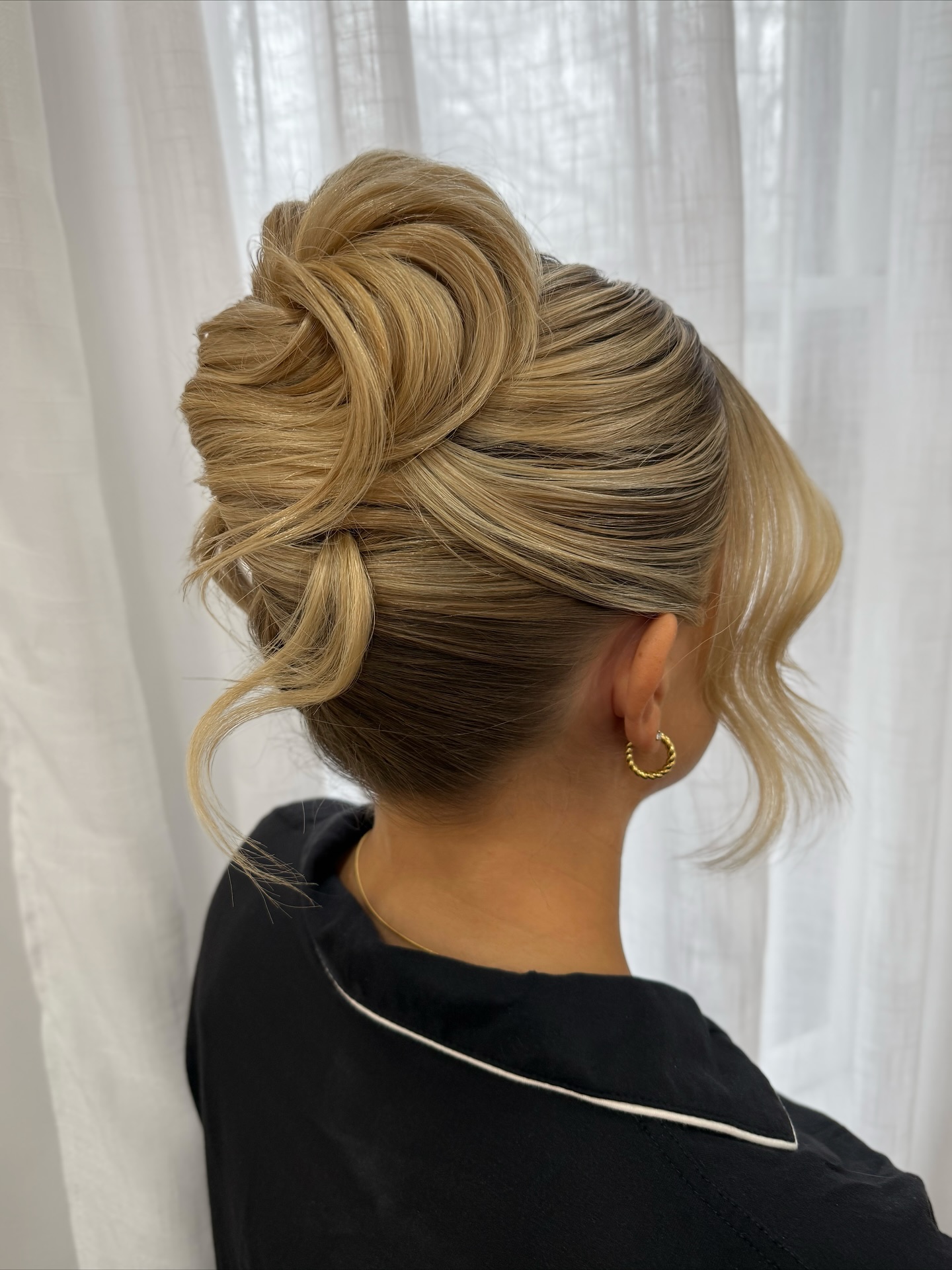 Modern sculpted French twist updo with loose front pieces