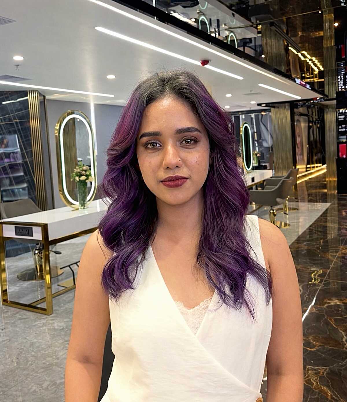 Long wavy hair with dark roots and deep violet color