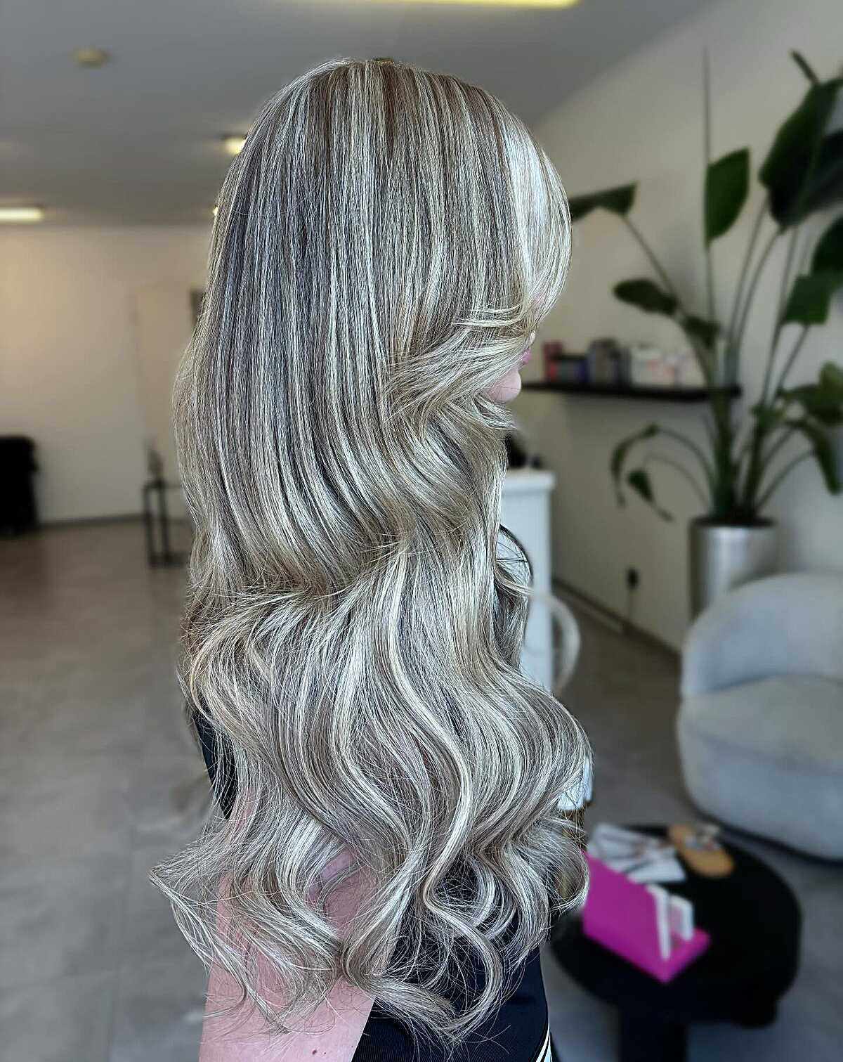 Long silver blonde waves with dark root shadow and curled ends