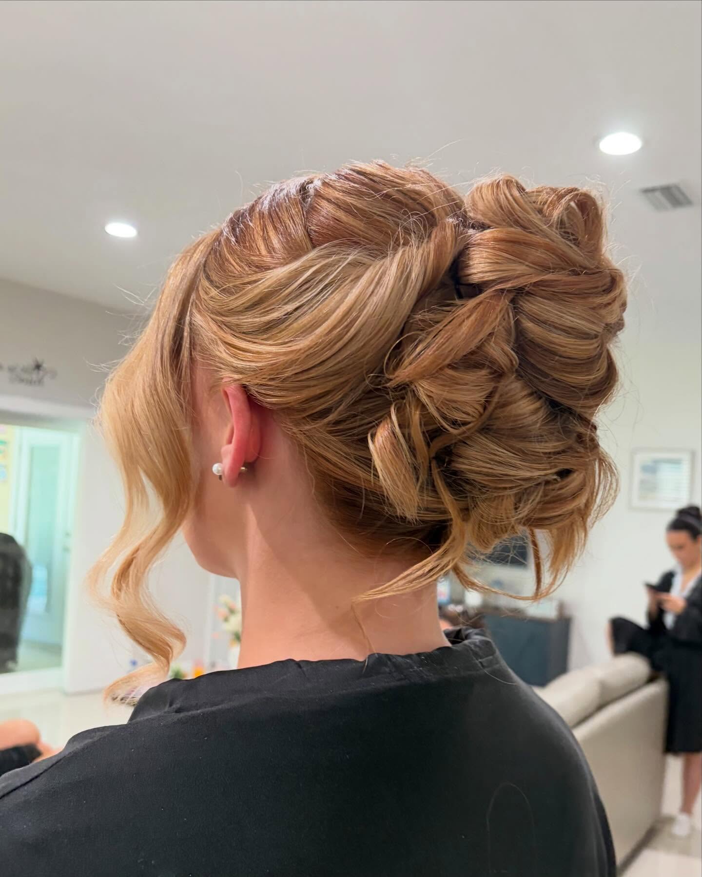 Textured twisted updo bun in warm strawberry blonde
