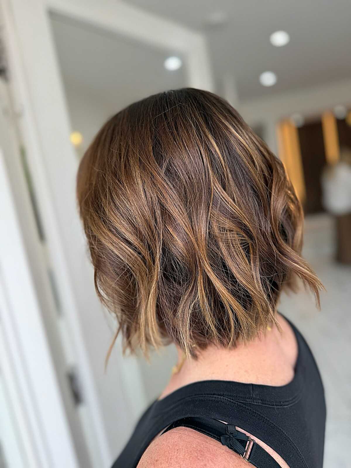 Short wavy brunette bob with caramel balayage