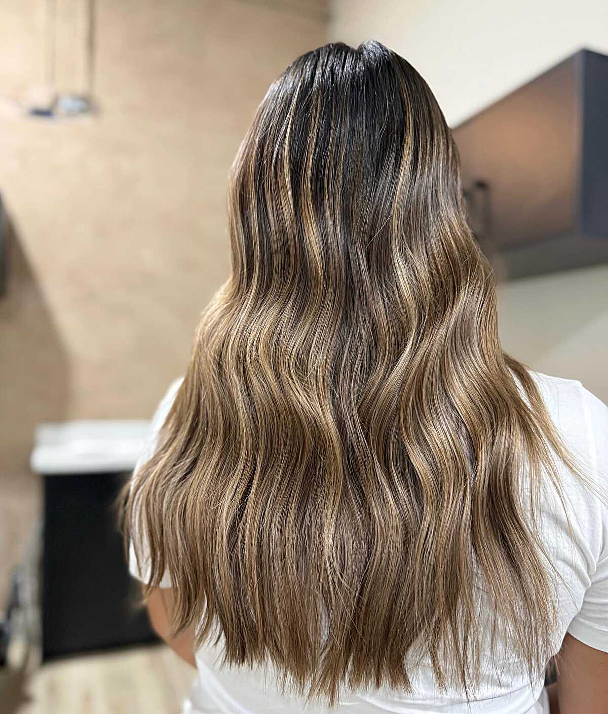 Long warm caramel bronde waves with dark root shadow