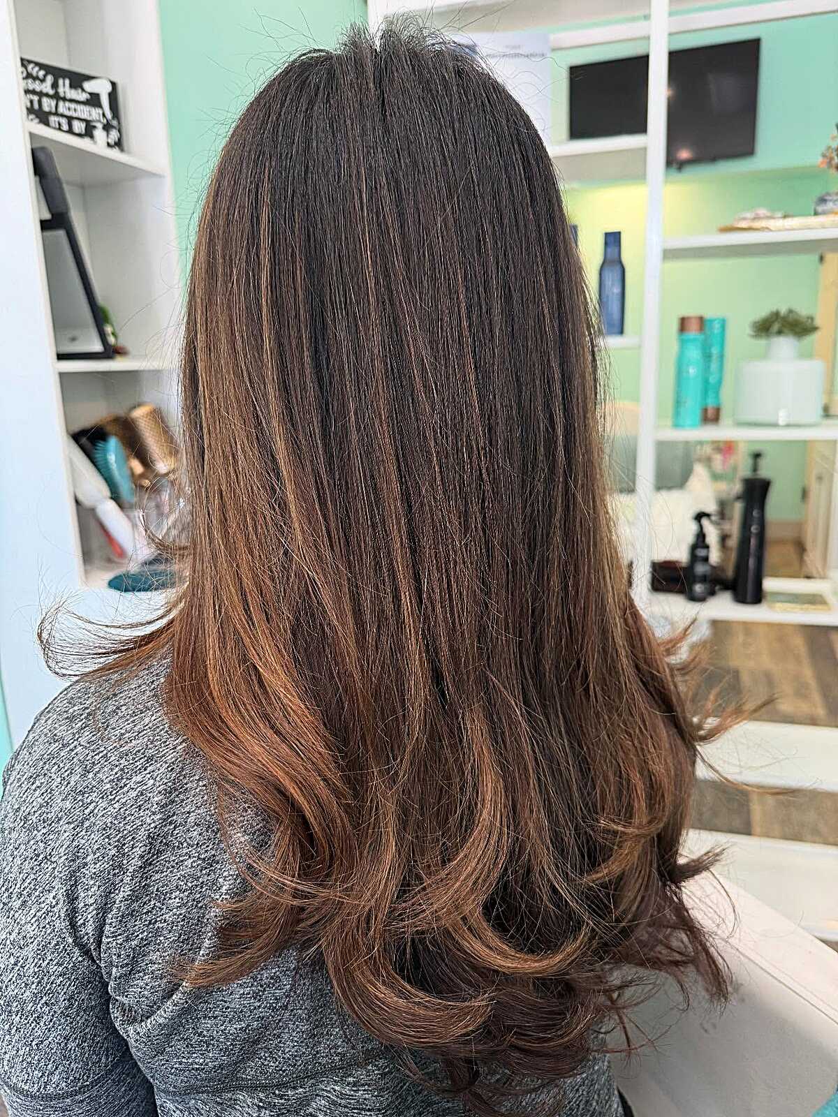 Medium brown hair fading to warm cinnamon at the ends