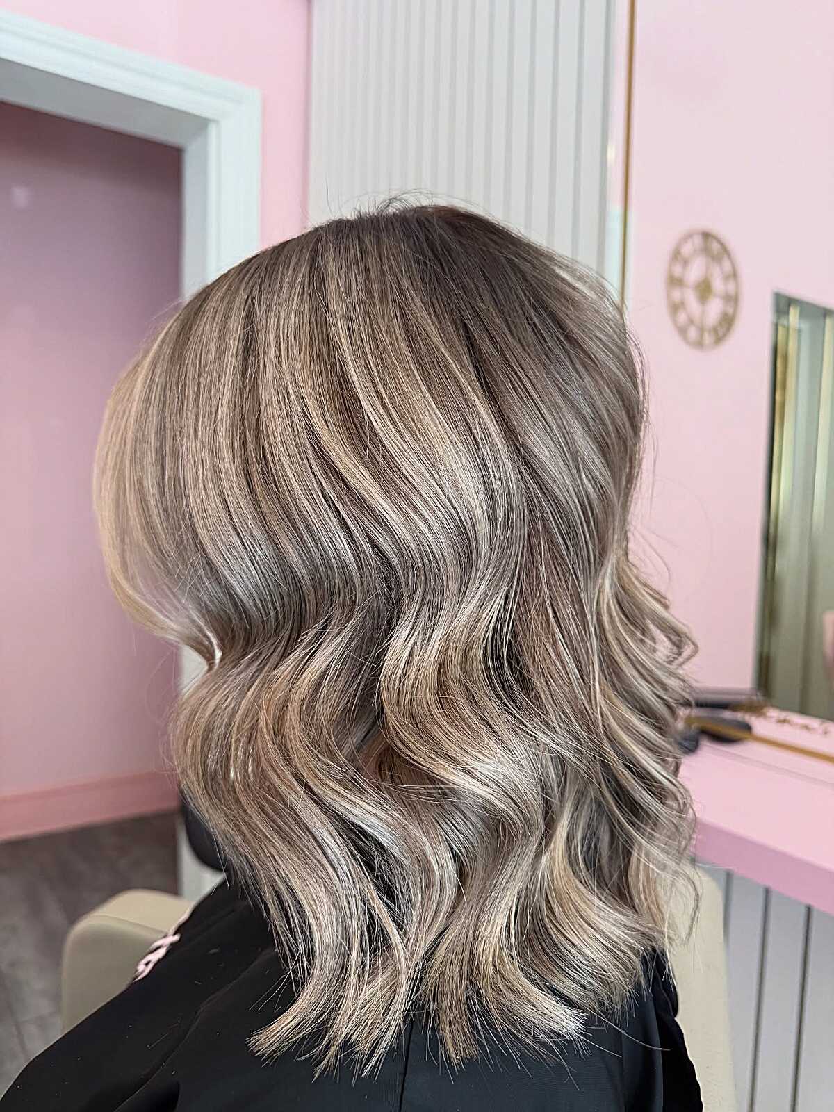 Wavy ash blonde lob with cool highlights and dimension