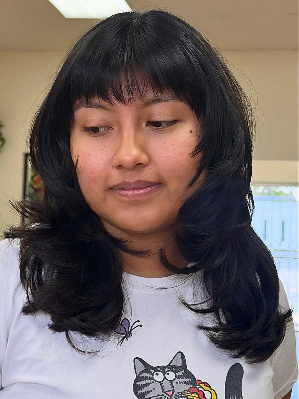 Jet black medium hair with straight bangs and flipped ends