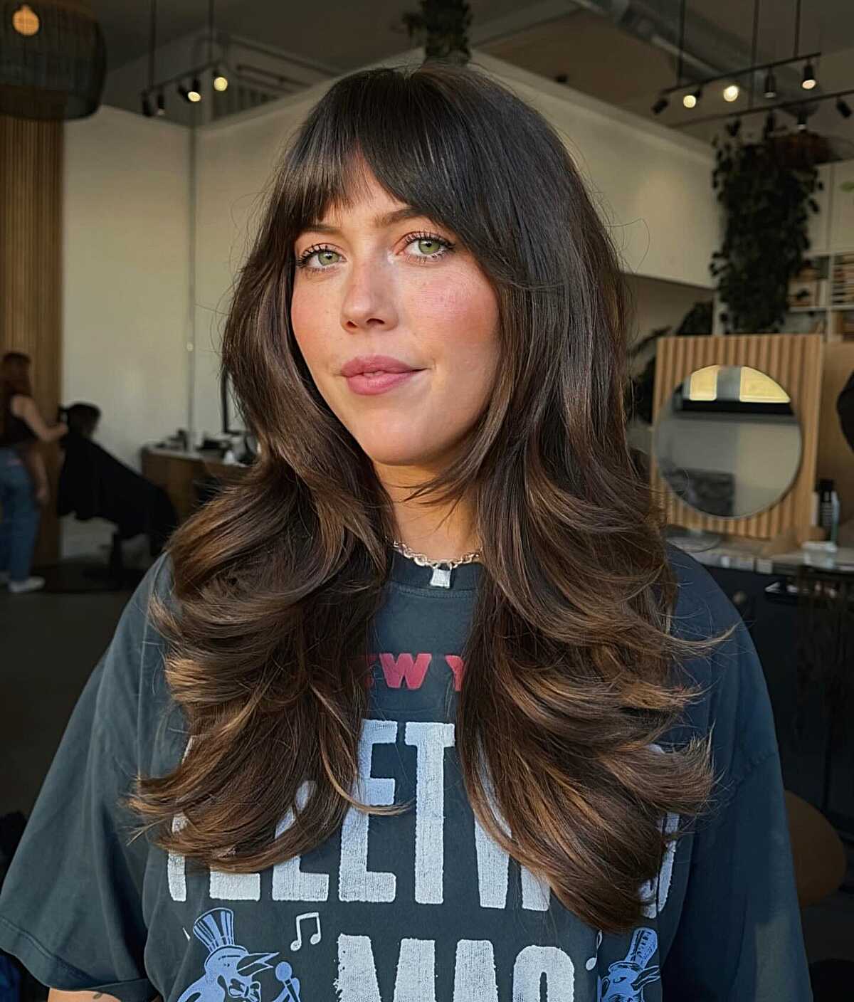 Long dark brown layers with full bangs and flipped ends