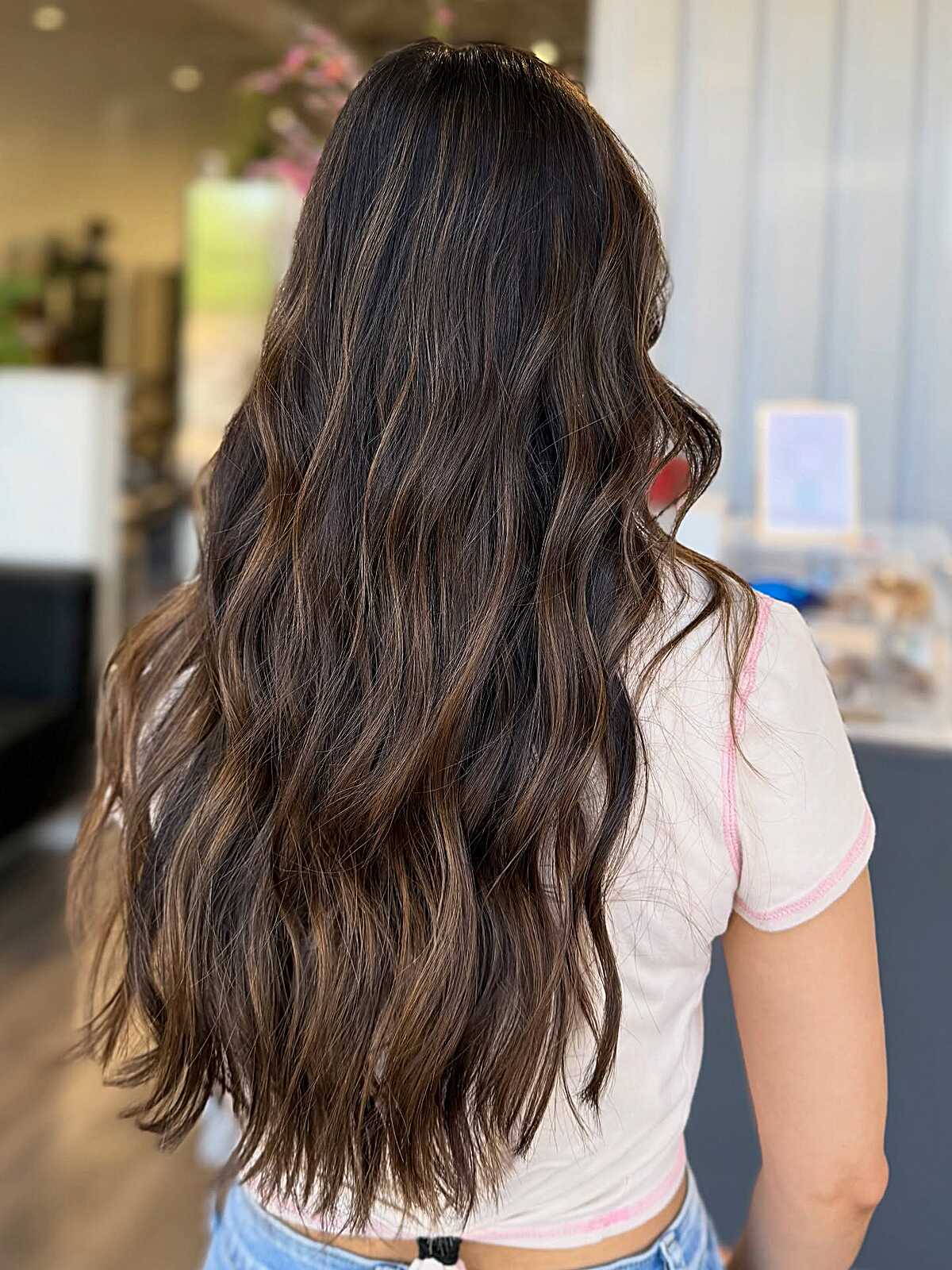 Long dark brown hair with subtle warm balayage highlights