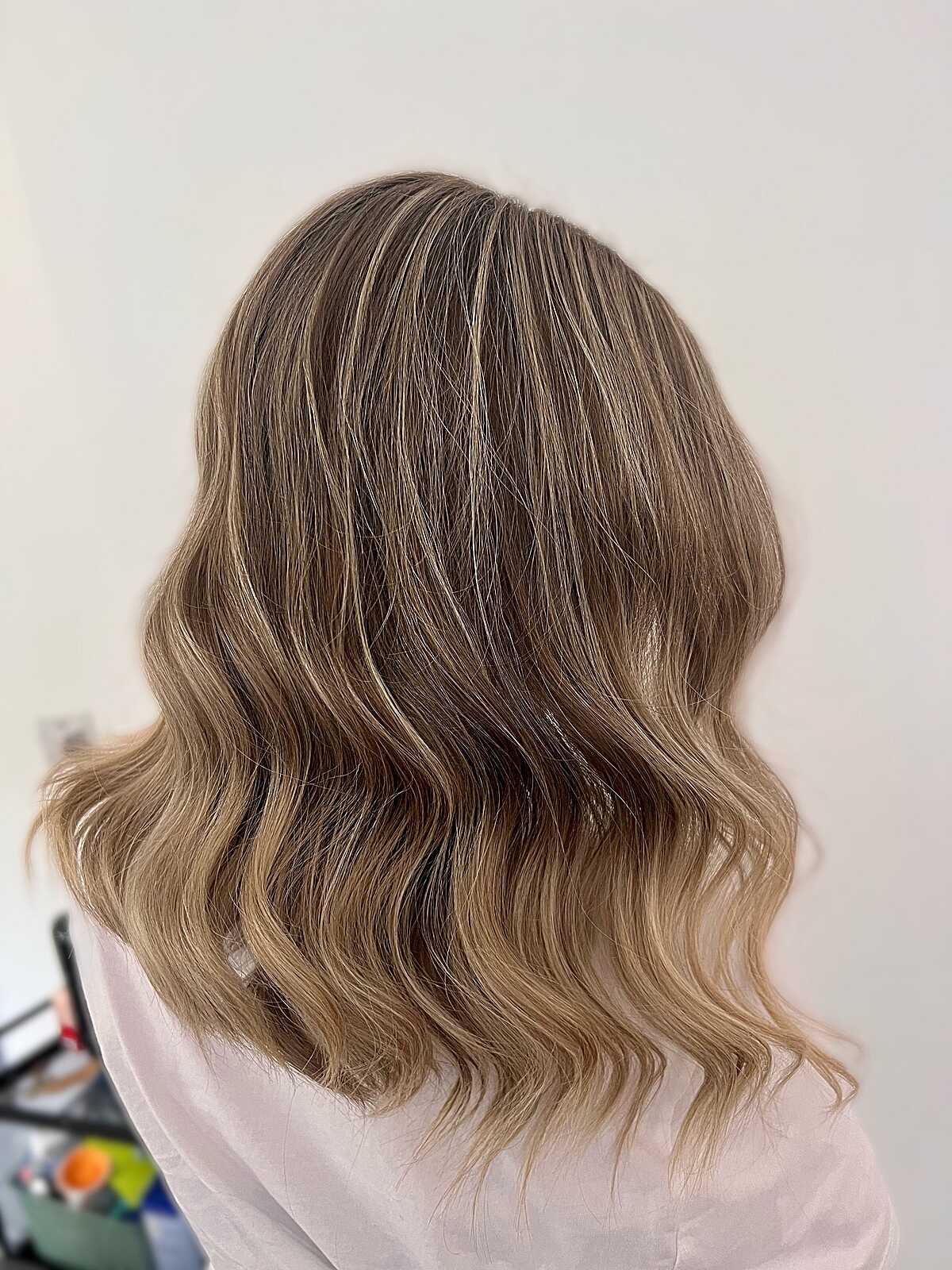 Medium-length sandy blonde balayage lob with waves