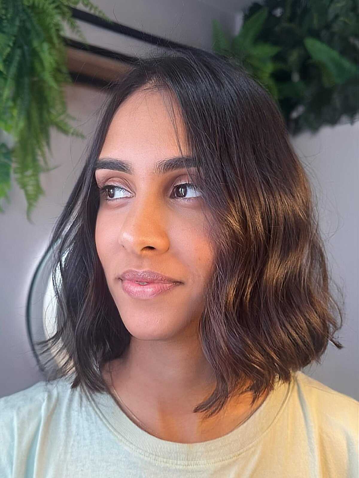 Textured wavy lob with warm balayage on dark hair