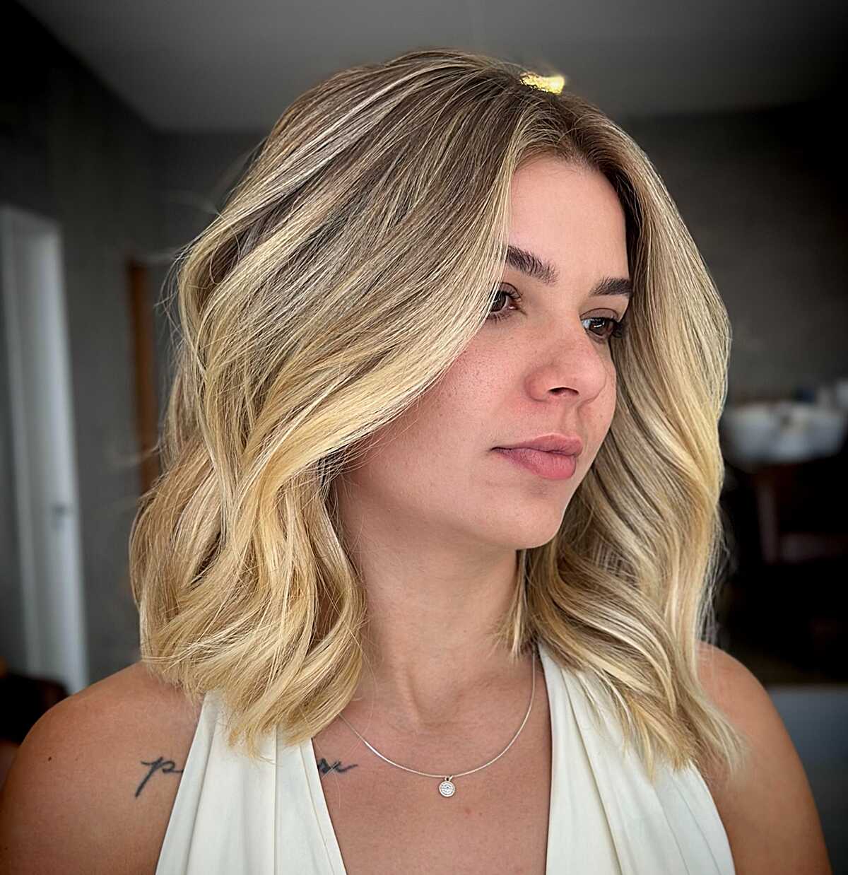 Warm honey blonde balayage lob with beach waves