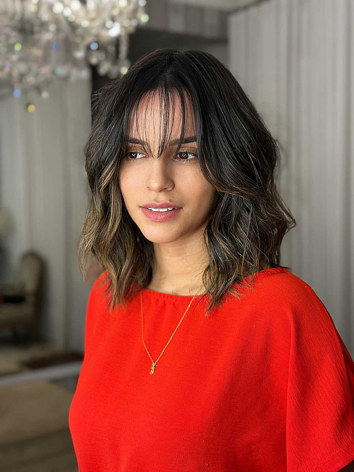 Wavy brunette lob with highlights and curtain bangs