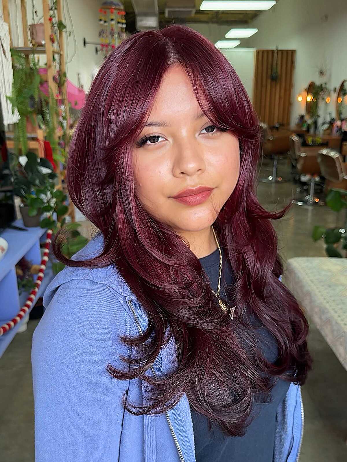 Deep burgundy long layered blowout with curtain bangs