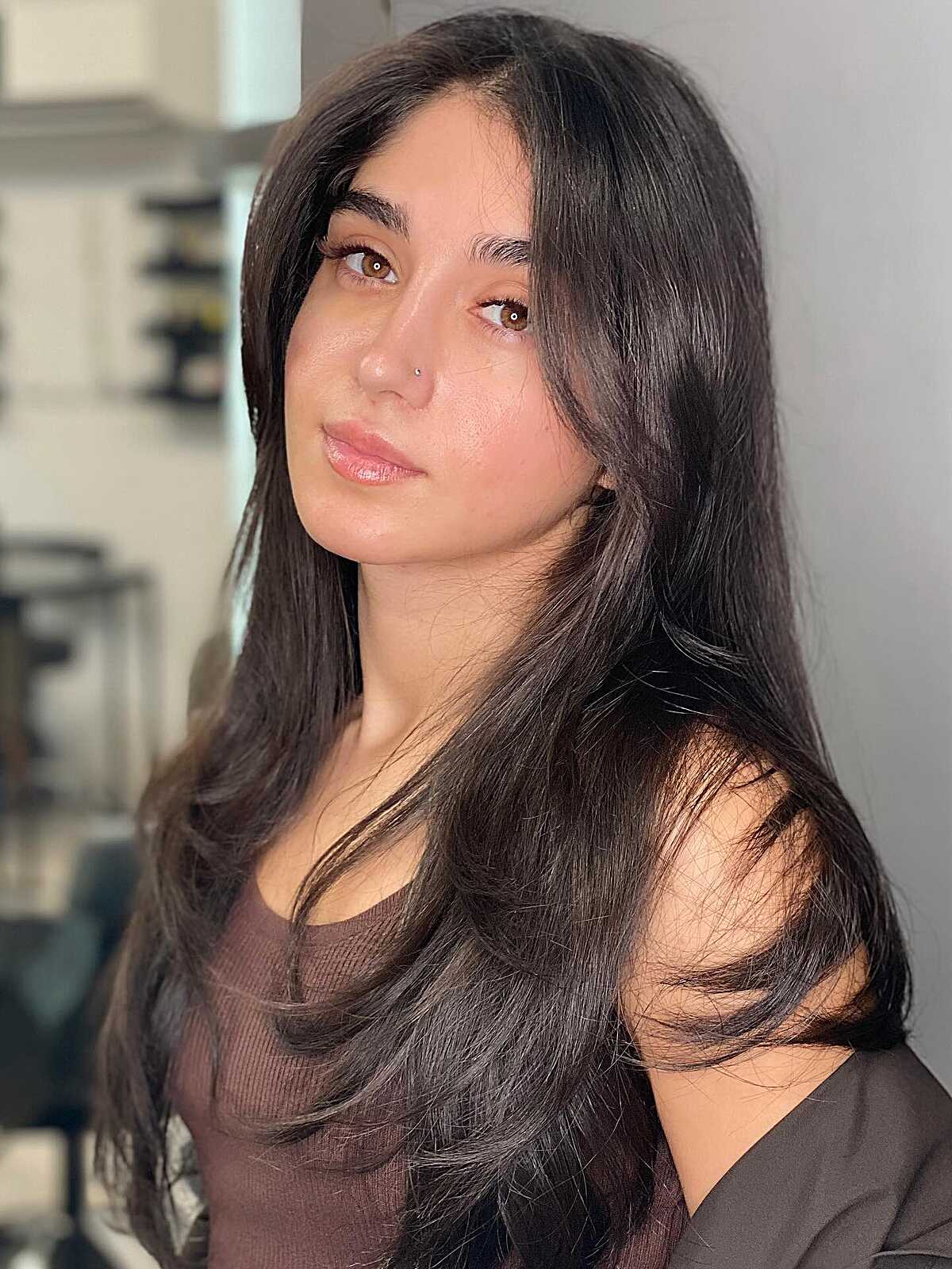 Long dark brown hair with minimal layers and subtle bangs