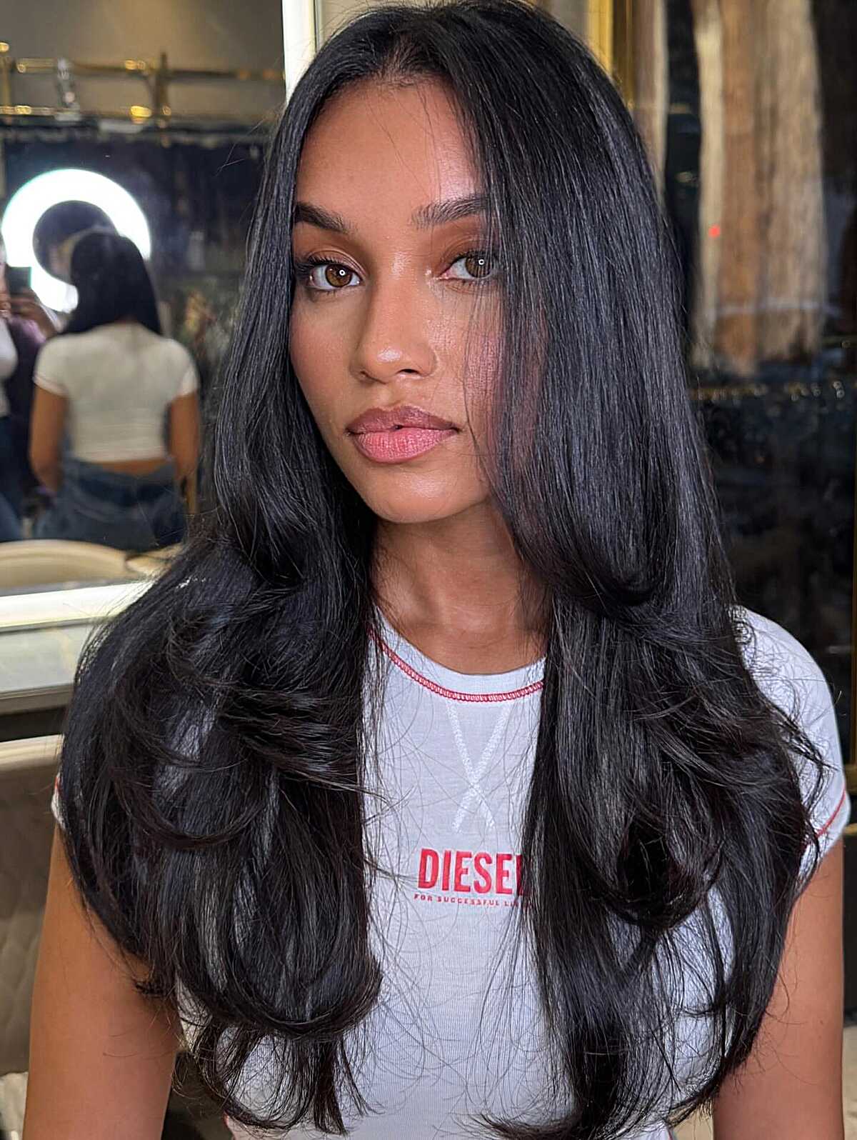 Glossy black long layered blowout with curtain bangs