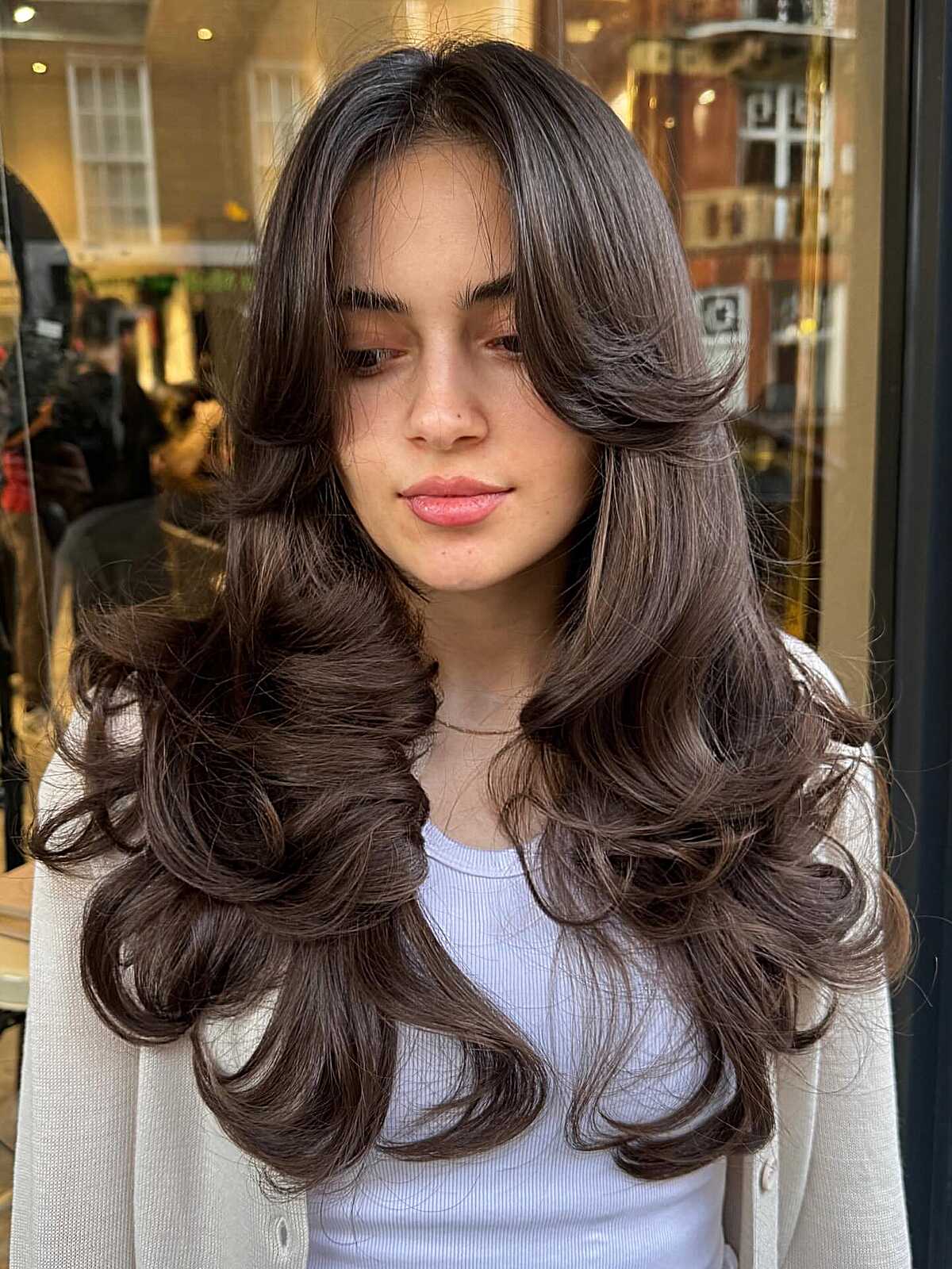 Long brunette voluminous curls with curtain bangs