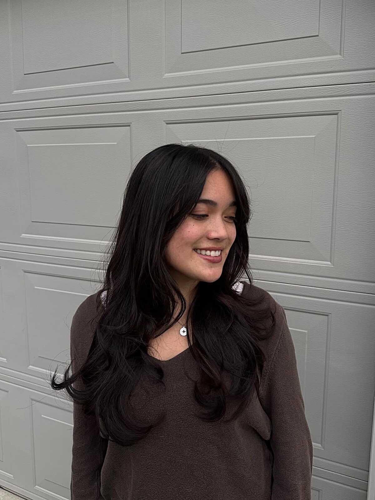 Jet black wavy long layers with soft curtain bangs